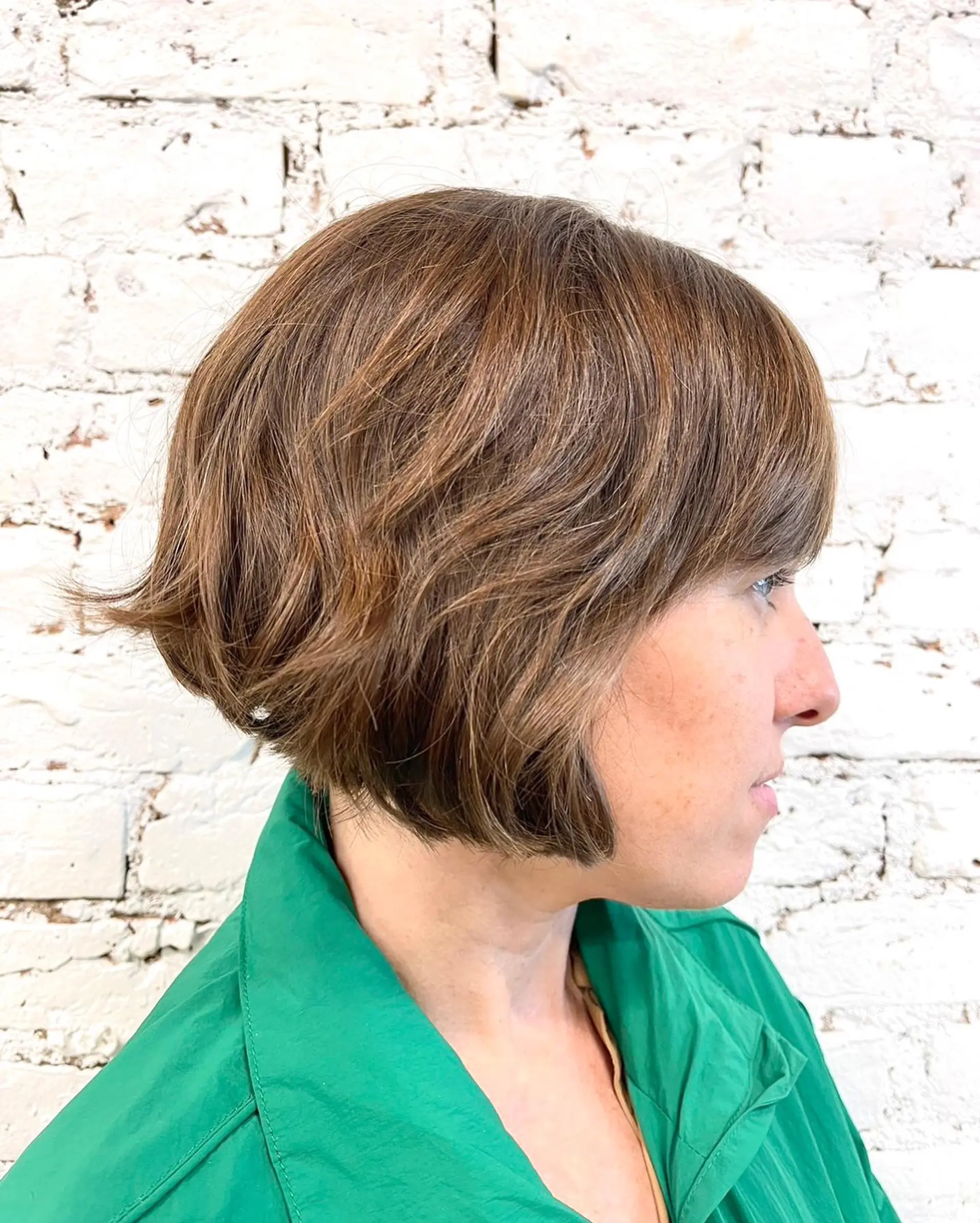 A textured short bob haircut with soft movement, wispy fringe, and gently flicked ends. 1