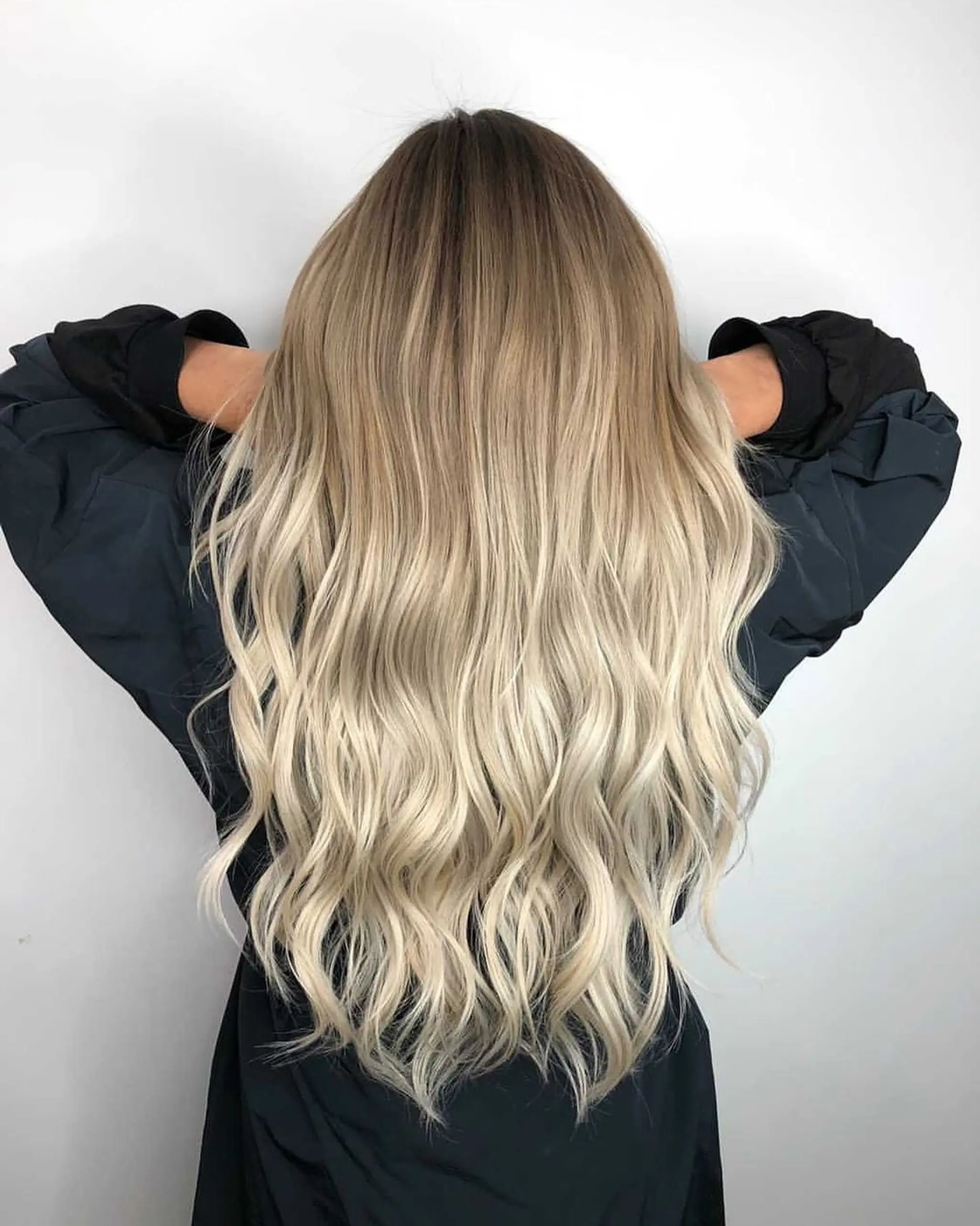 An impeccable ombre hairstyle featuring very long hair that transitions from dark blonde at the roots to platinum blonde at the ends. The wavy texture creates a beach wave effect, with blended highlights and gradient for added depth and dimension.
Stylist - @xcellent_jason