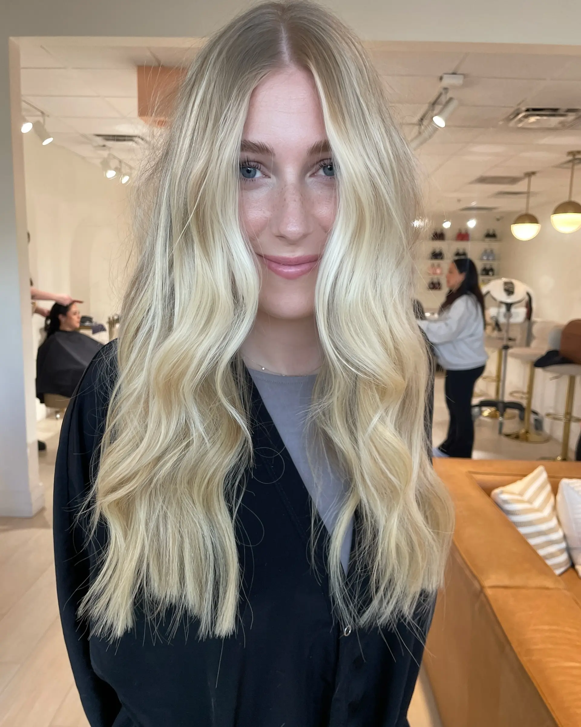 Long, luminous blonde hair styled in soft, undone waves with a center part and bright face-framing sections. 1