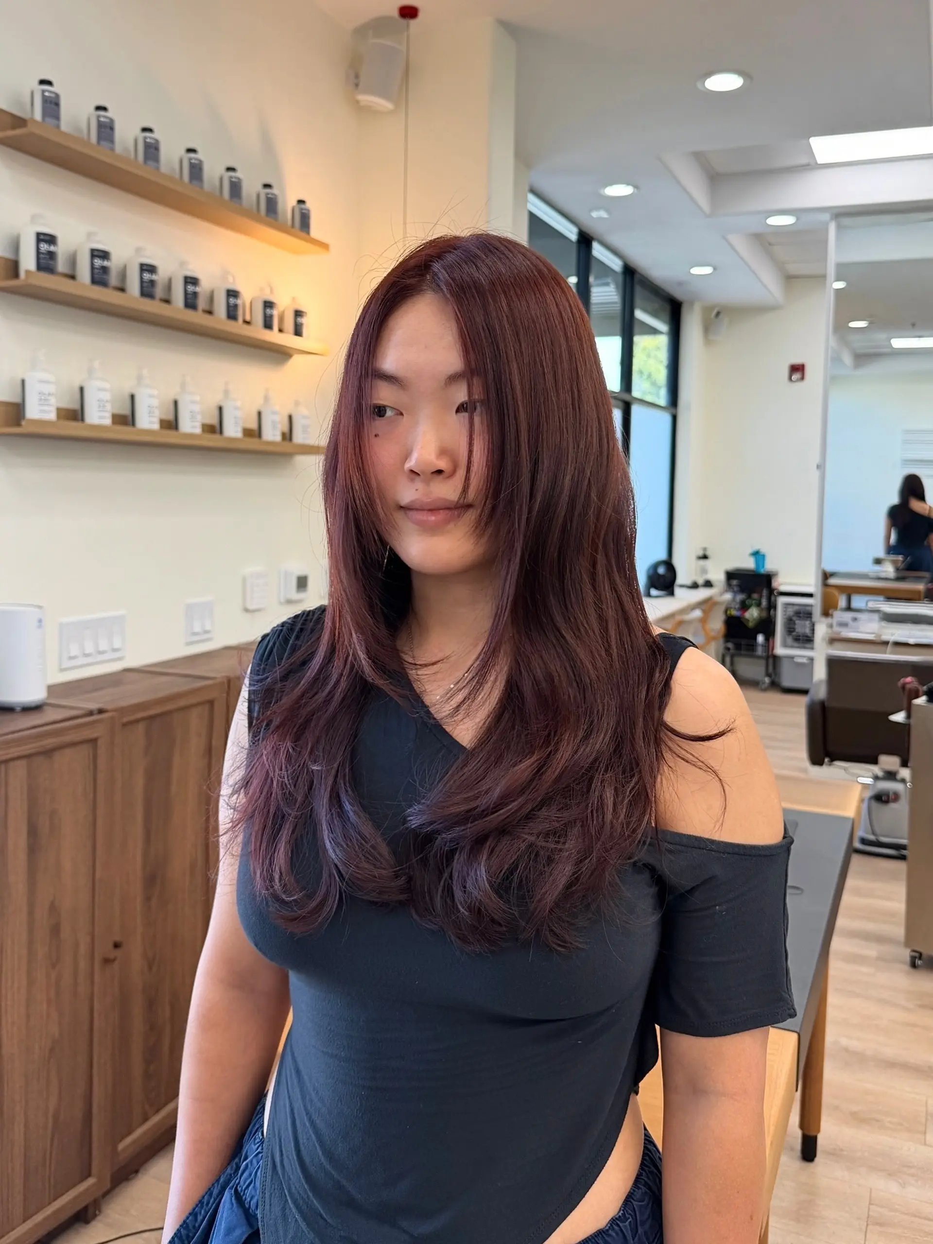 Long layered cut featuring a rich copper-red hue with softly curved ends and chin-length face-framing pieces. 1