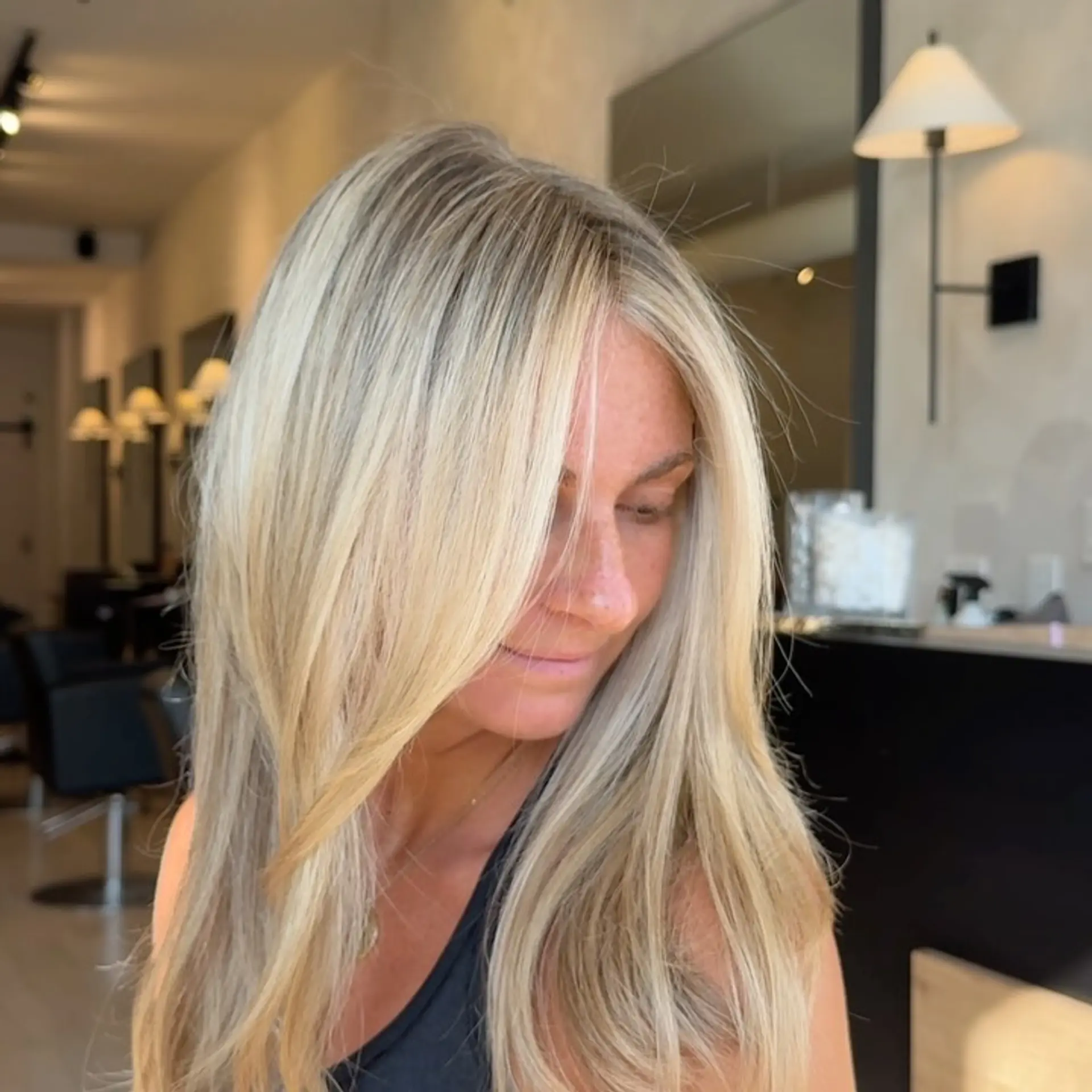 A bright, multi-tonal blonde style with soft face-framing fringe and smooth layers finished with a polished blowout. 1
