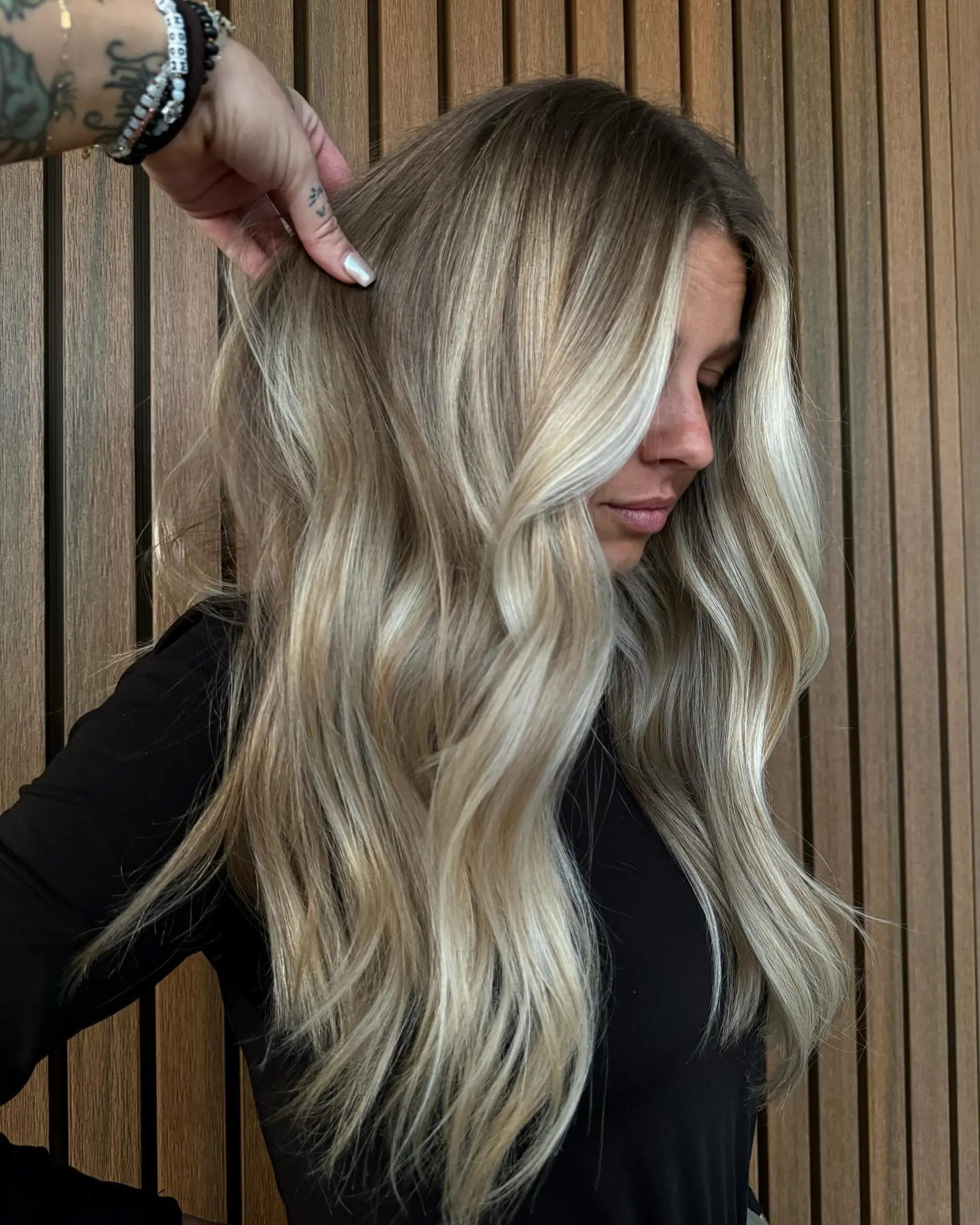 Long dimensional blonde hair styled in soft, cascading waves with a natural shadow root and bright face-framing pieces. 1