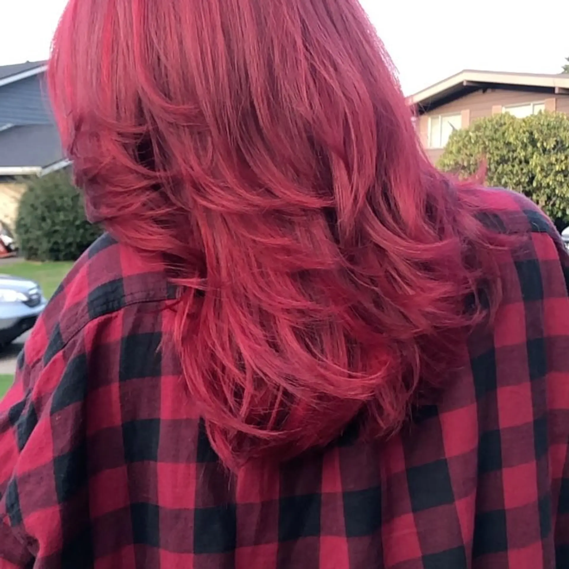 Medium-length vibrant crimson-red hair cut with textured, cascading feathered layers. 1