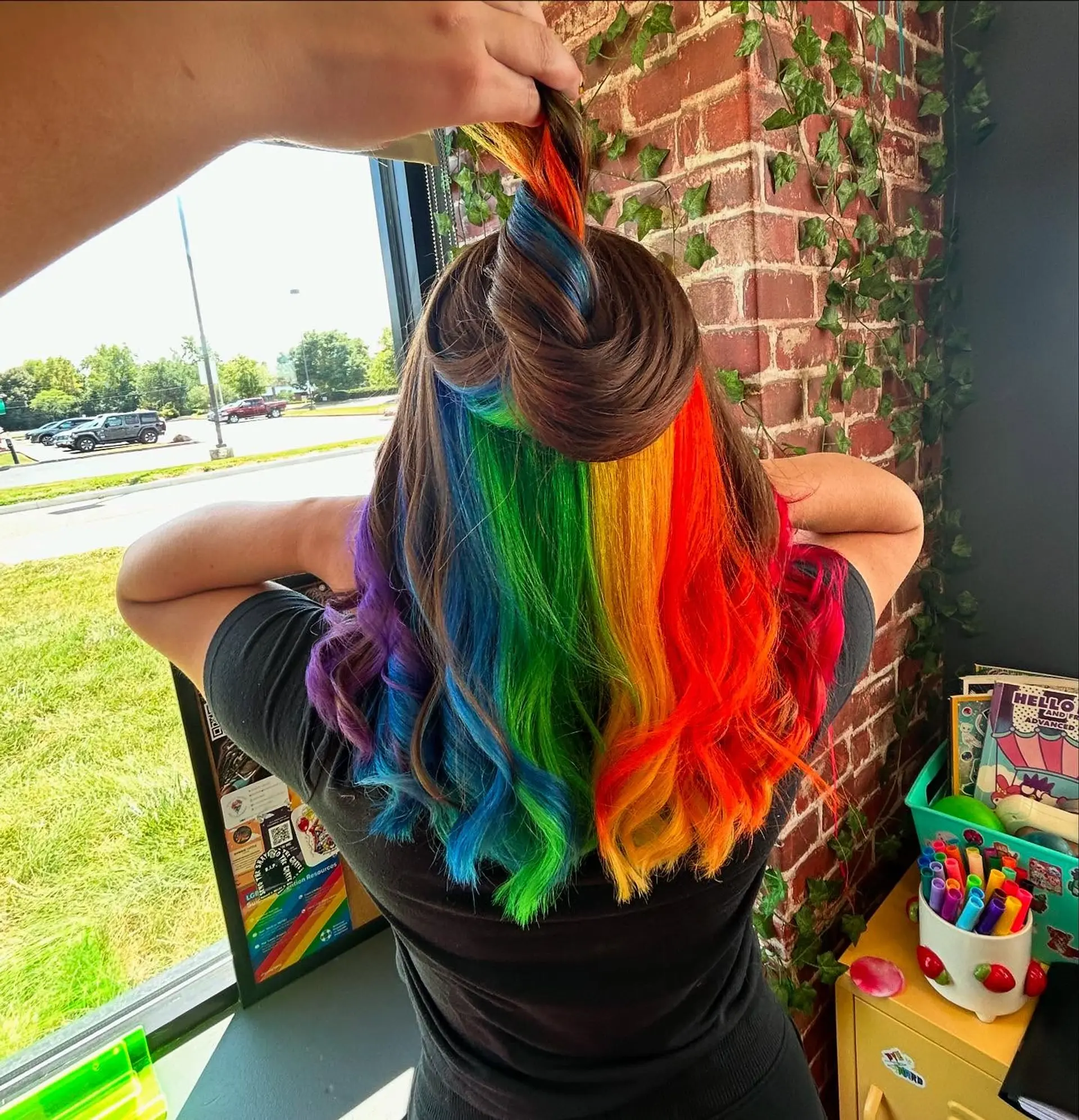 Shoulder-length brunette hair revealing a vibrant full-spectrum rainbow peek-a-boo underlayer. 1