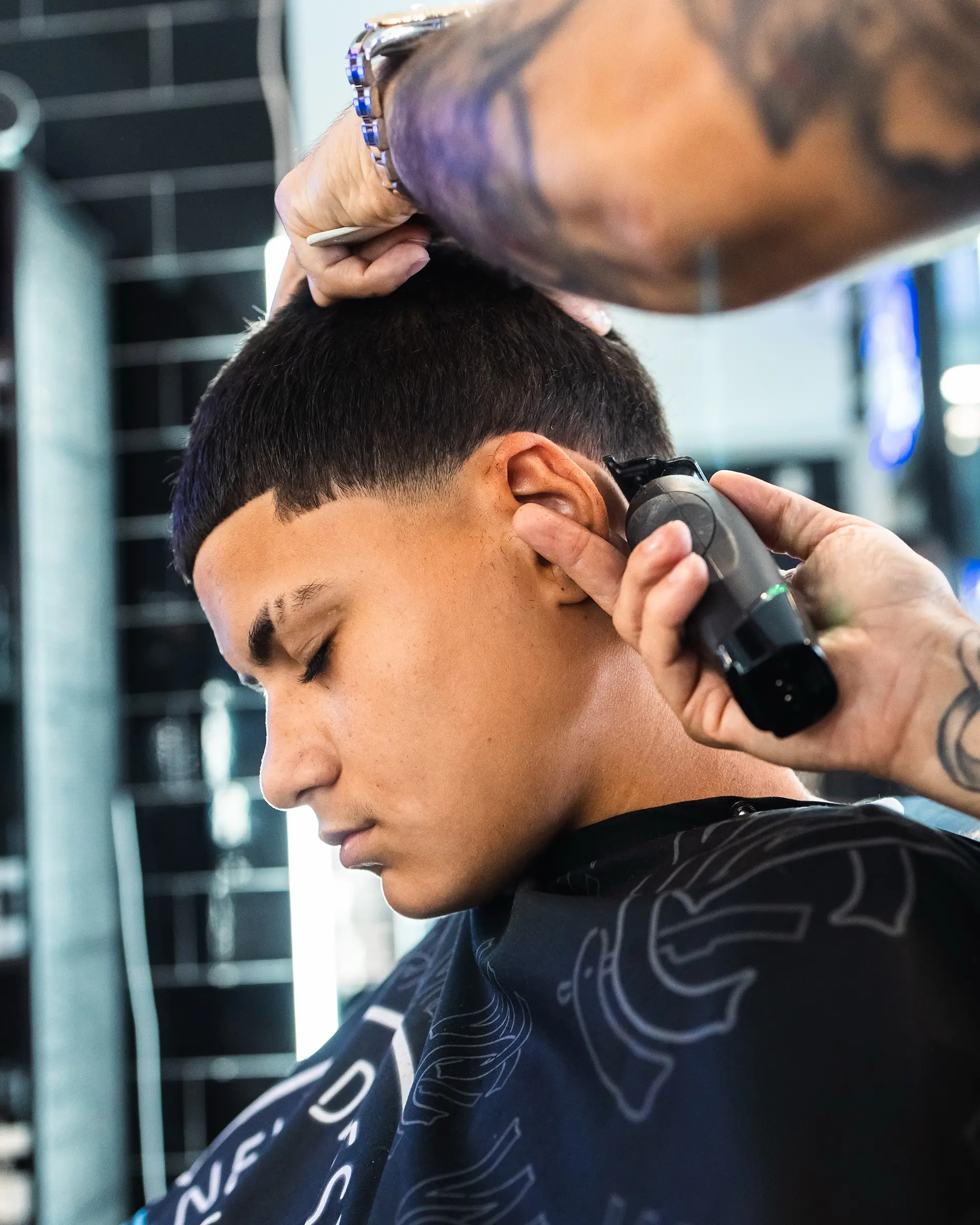A neat short crop featuring a straight-edge front line and a smooth taper fade around the ear. 1