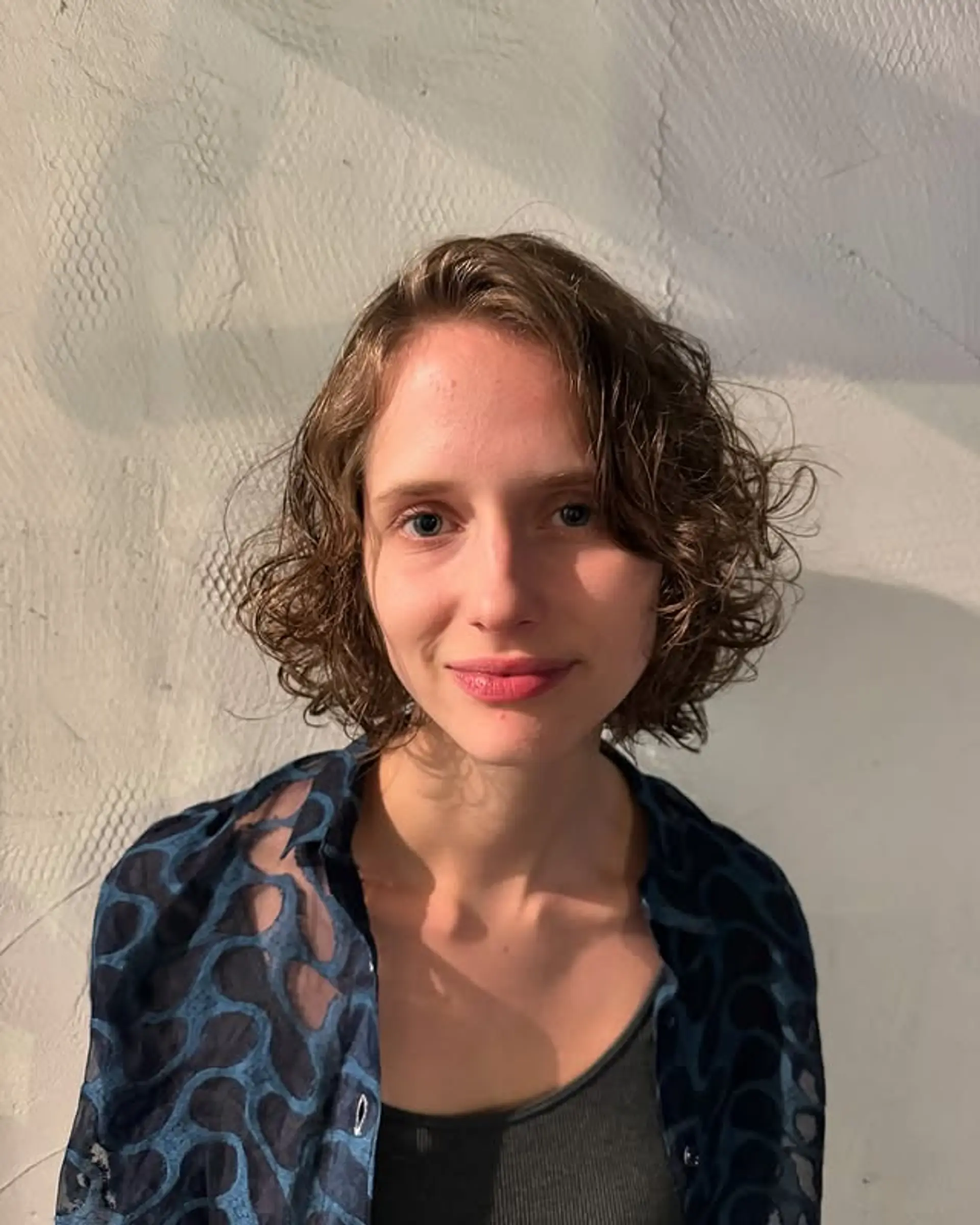 A curly bob with face-framing layers designed to enhance natural curls. 1