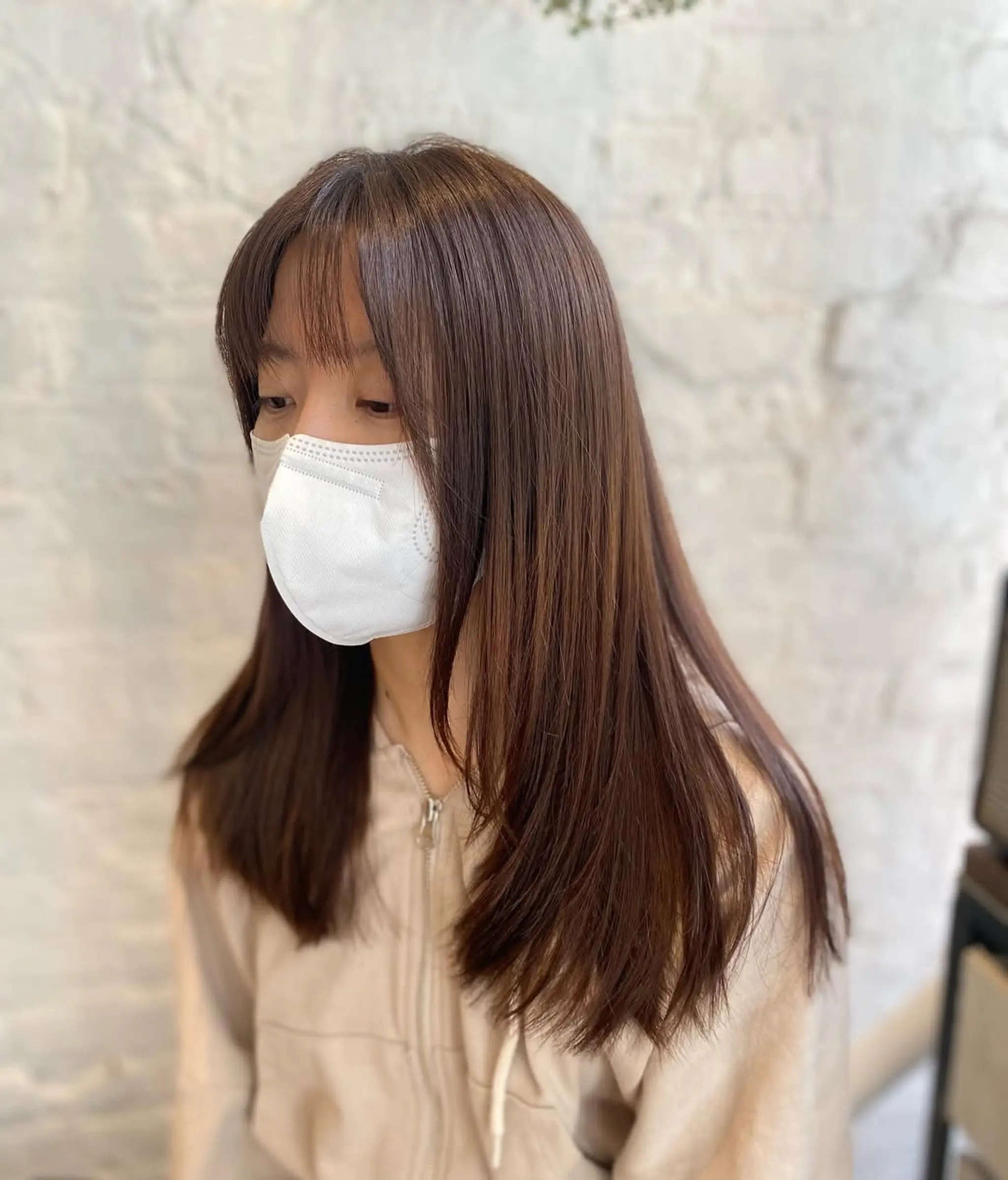 Long, layered haircut with face-framing curtain bangs.