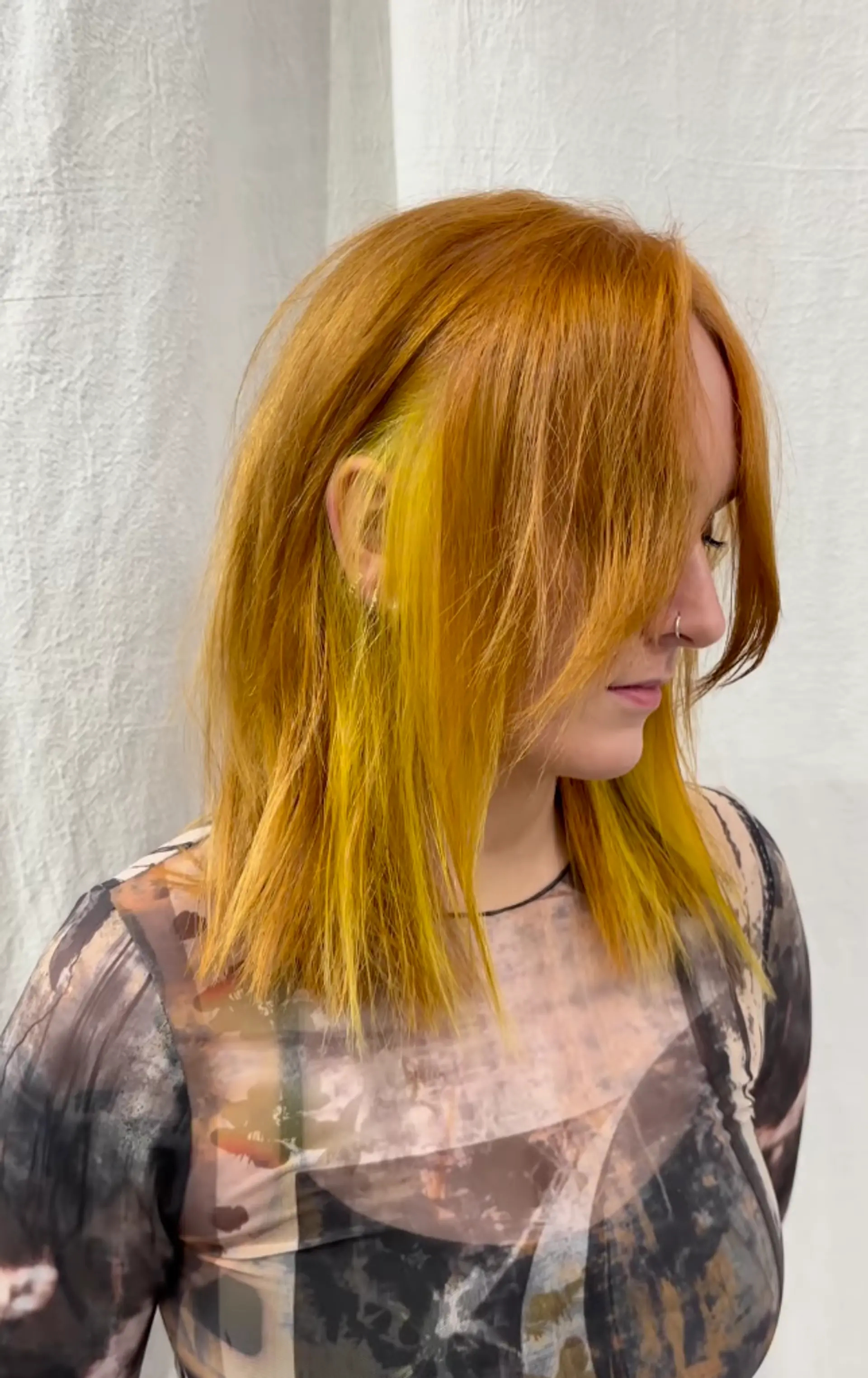 Medium-length copper hair with golden yellow highlights, featuring asymmetrical layers and a side-swept finish. 1