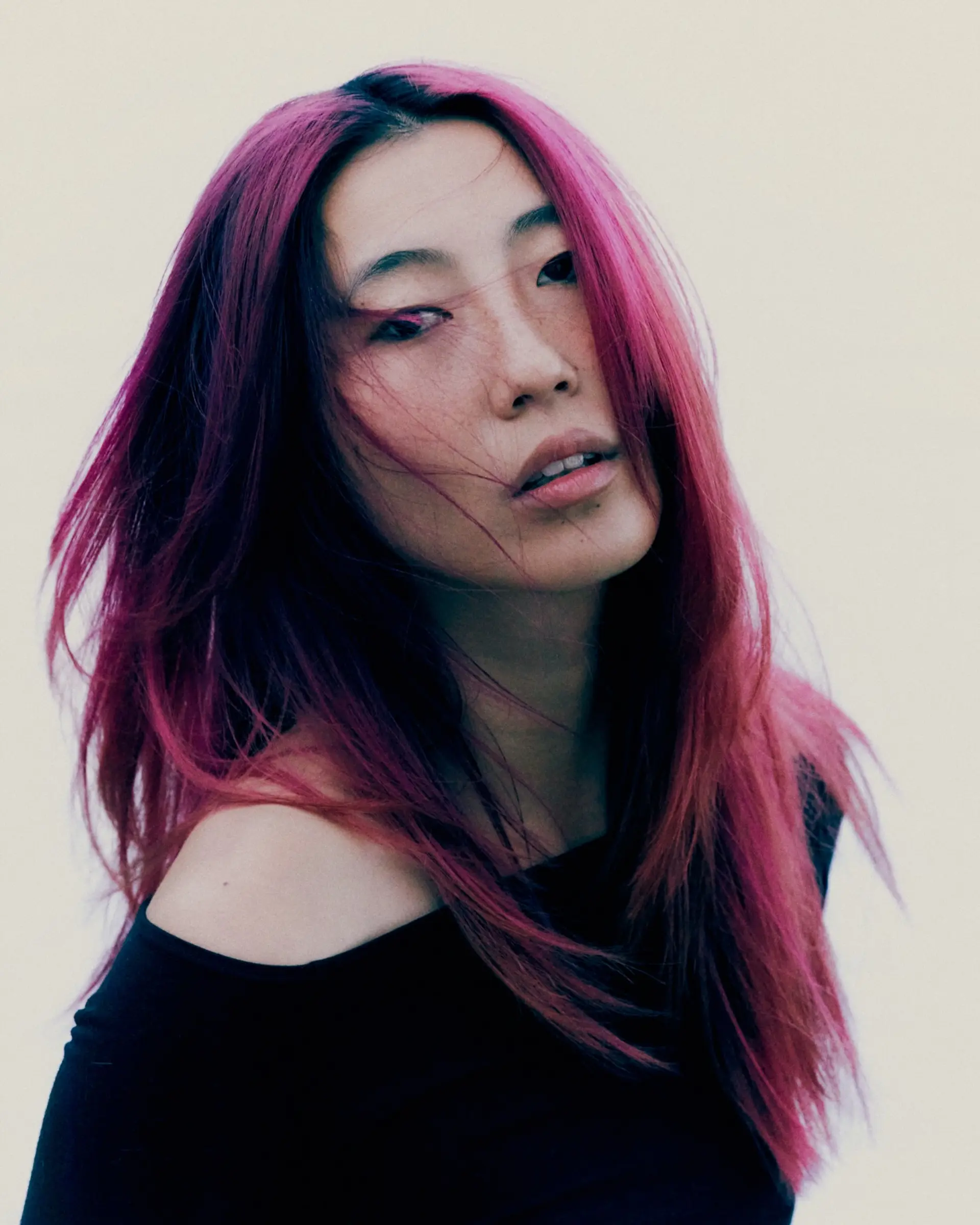 Vibrant magenta-pink long layered haircut styled with soft texture and a center part. 1