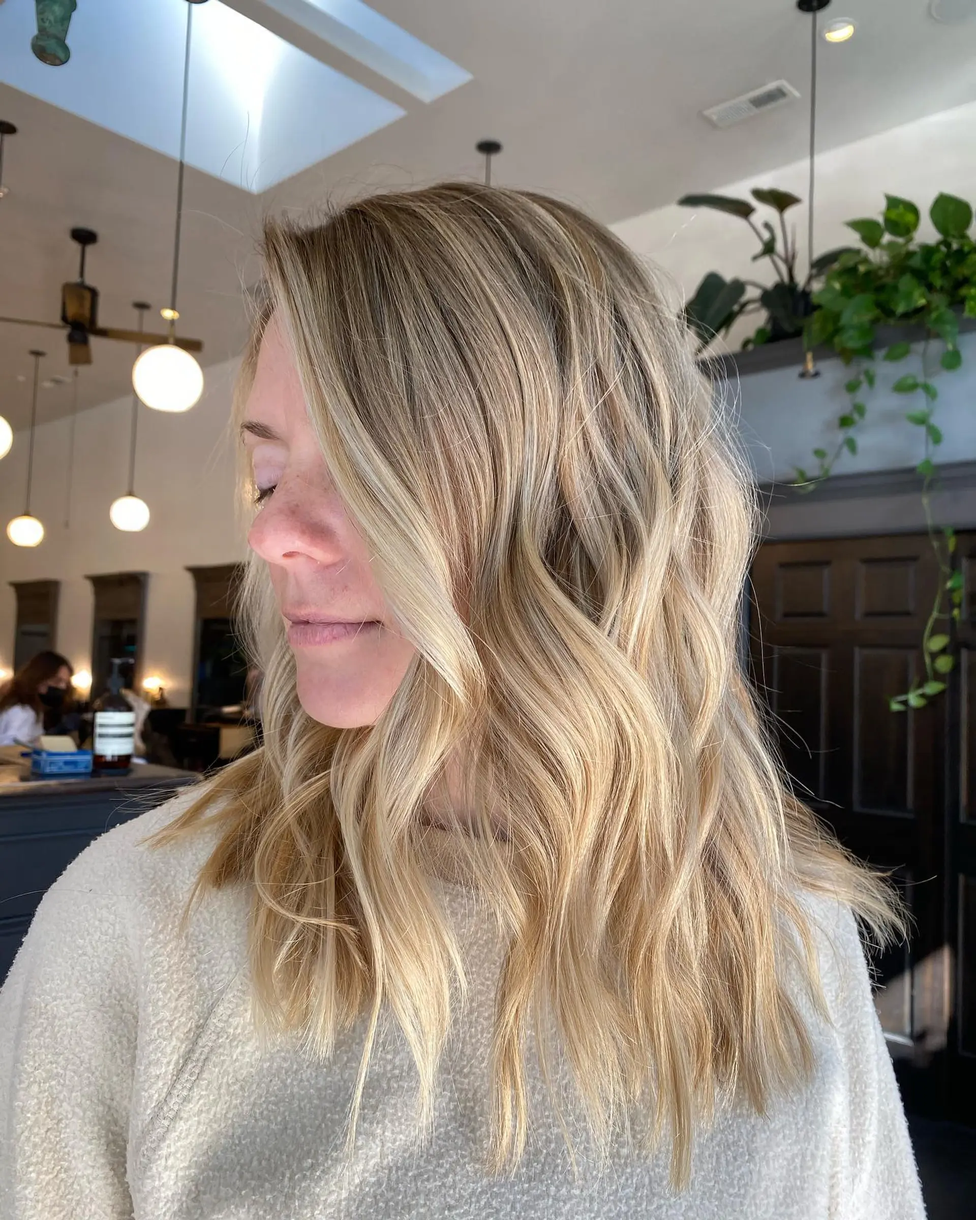 Long dimensional blonde hair styled in soft, undone waves with bright face-framing accents. 1