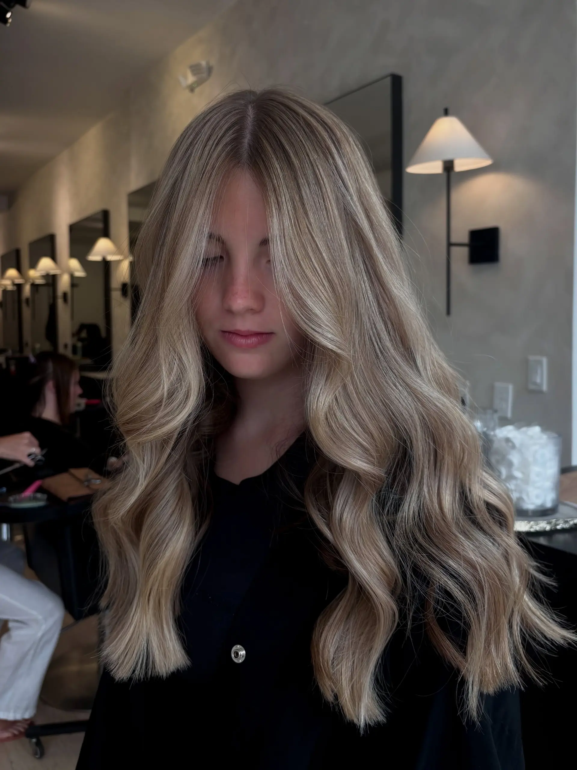 Long dimensional blonde hair styled into soft, flowing loose waves with face-framing pieces. 1