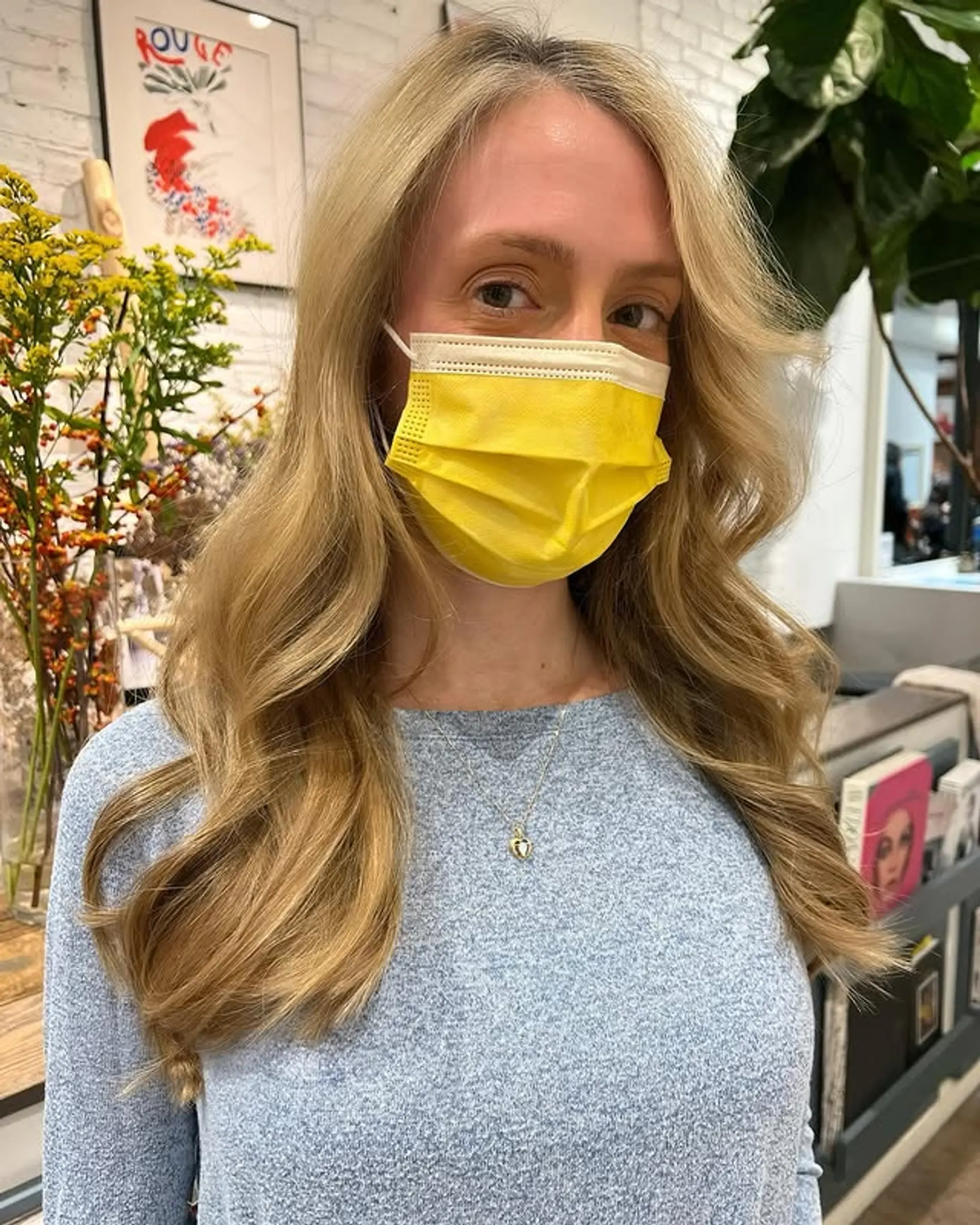 Wavy medium-length hairstyle with face-framing layers, styled with a golden blonde hue. 1