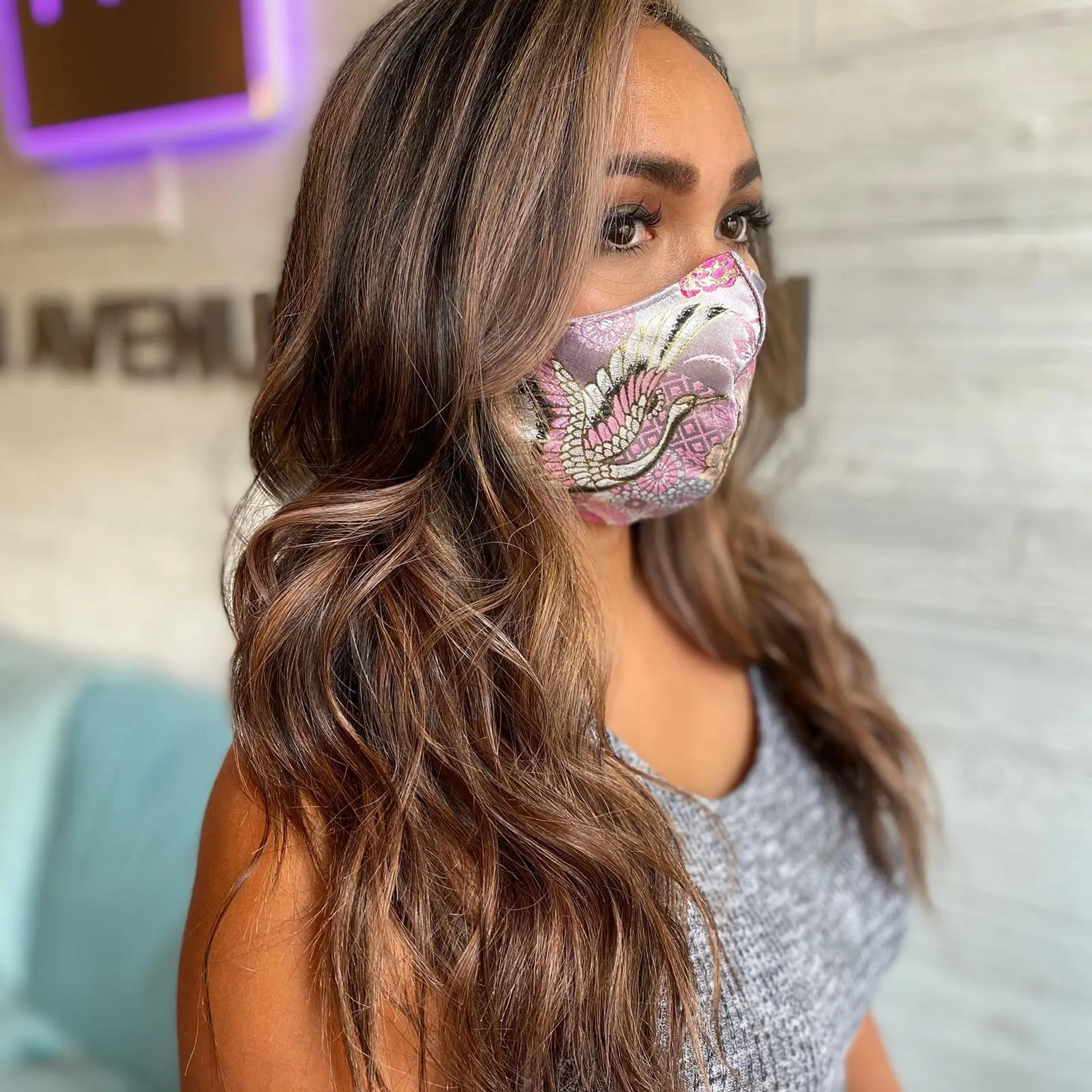 Long wavy brunette hair styled with dimensional caramel and light brown balayage highlights. 1