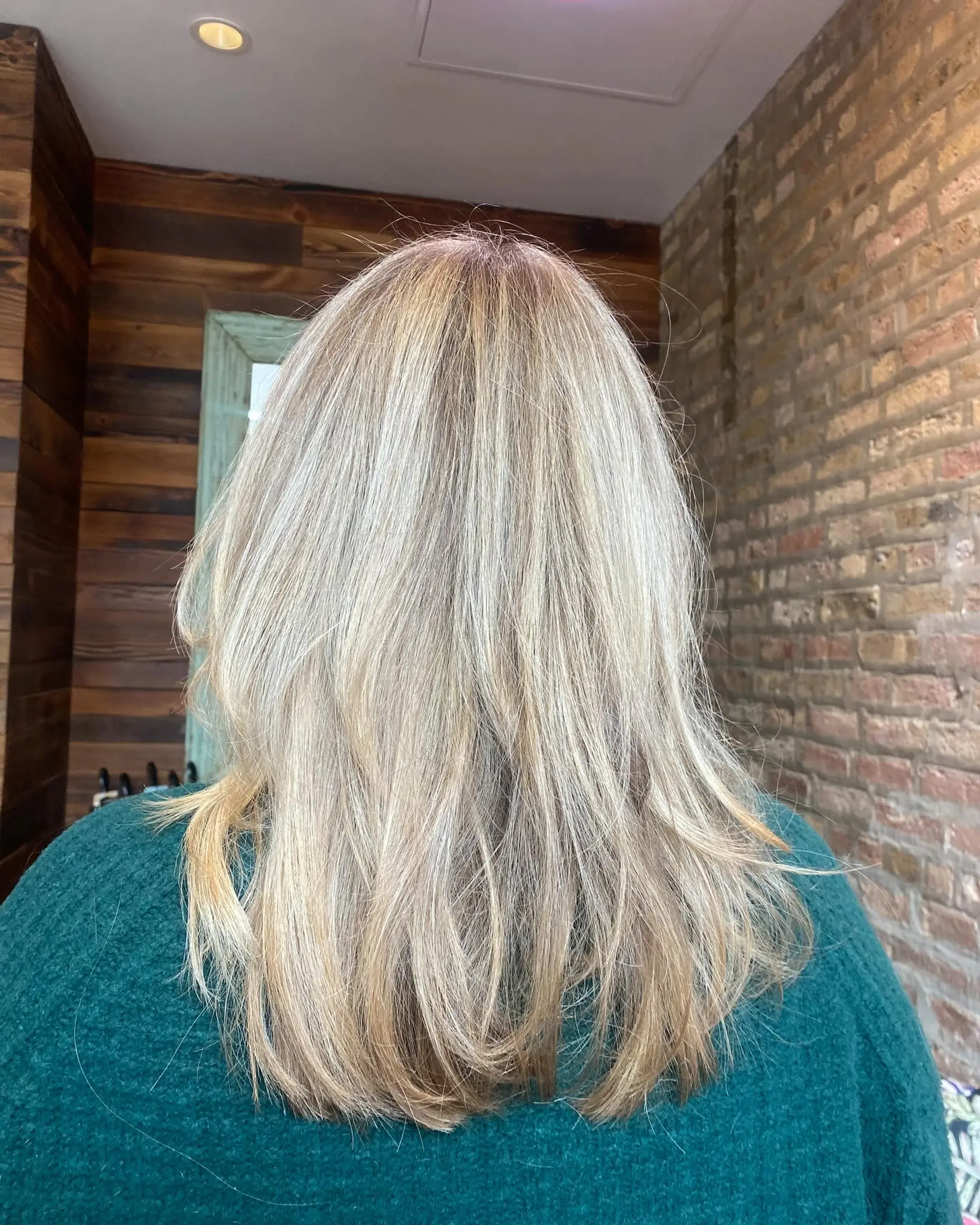 A medium length layered hairstyle with bronde balayage highlights. The textured layers create movement and a beachy wave effect. 2