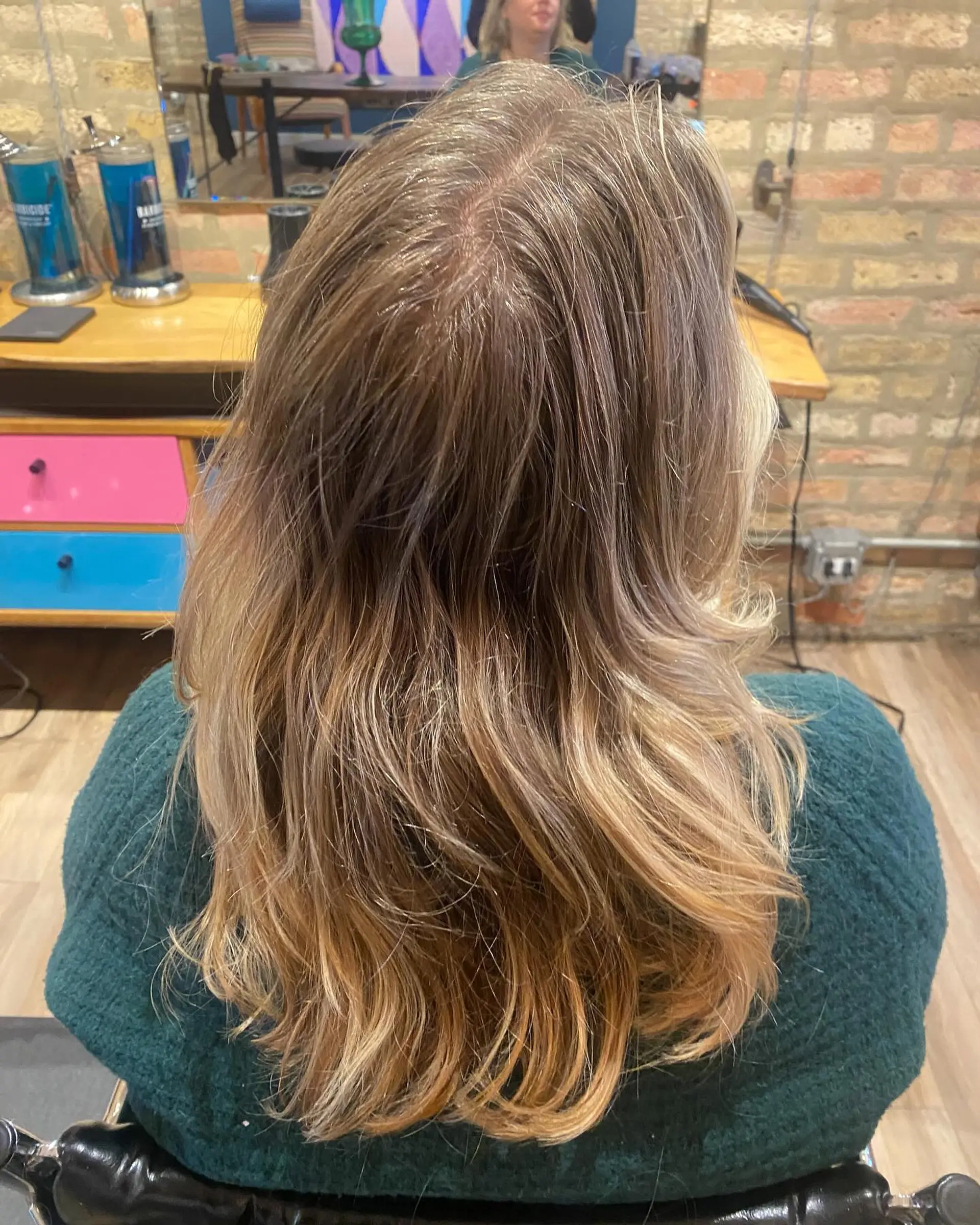 A medium length layered hairstyle with bronde balayage highlights. The textured layers create movement and a beachy wave effect. 3