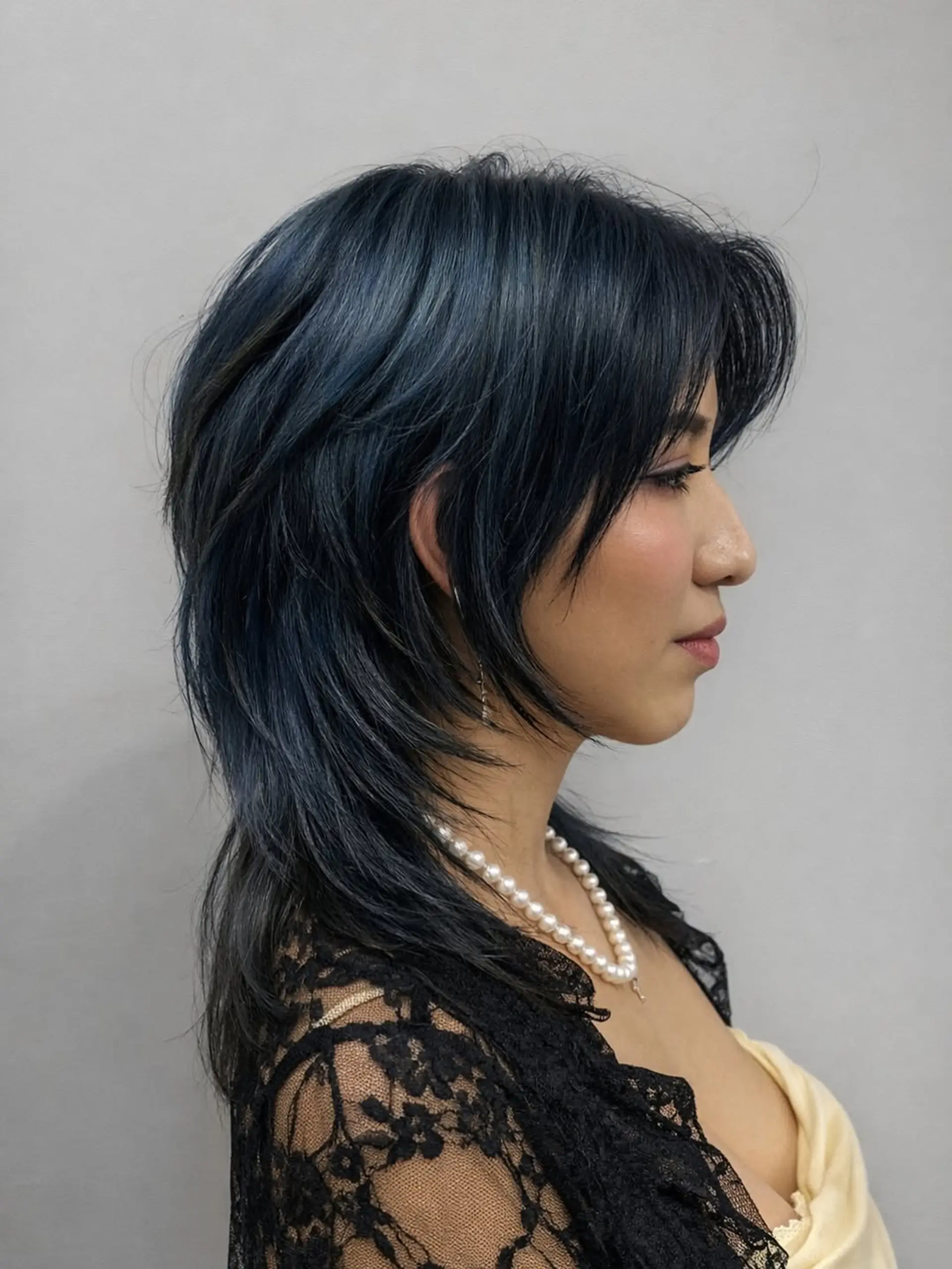 A layered, choppy wolf cut with significant texture and volume around the crown, transitioning into thinner, longer pieces through the back, paired with face-framing fringe. 1