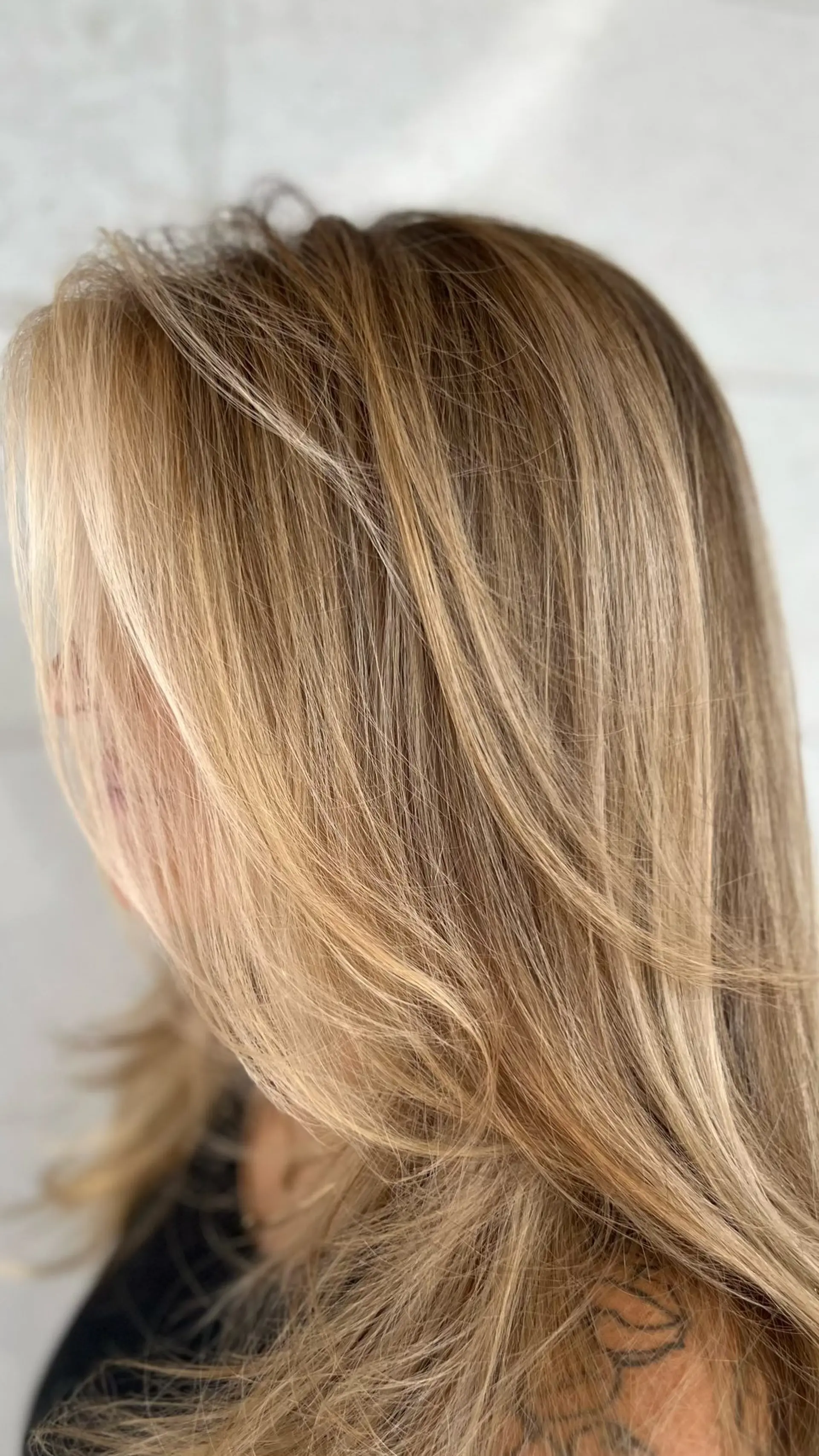 Dimensional warm blonde balayage featuring bright face-framing highlights and a smooth, soft blowout. 1