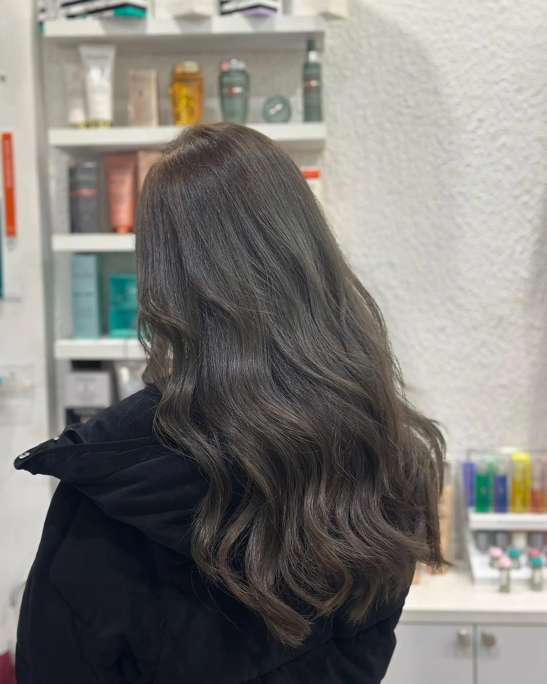 Long, wavy ash brown hair with soft, layered waves and natural shine, creating a voluminous and textured look. 1