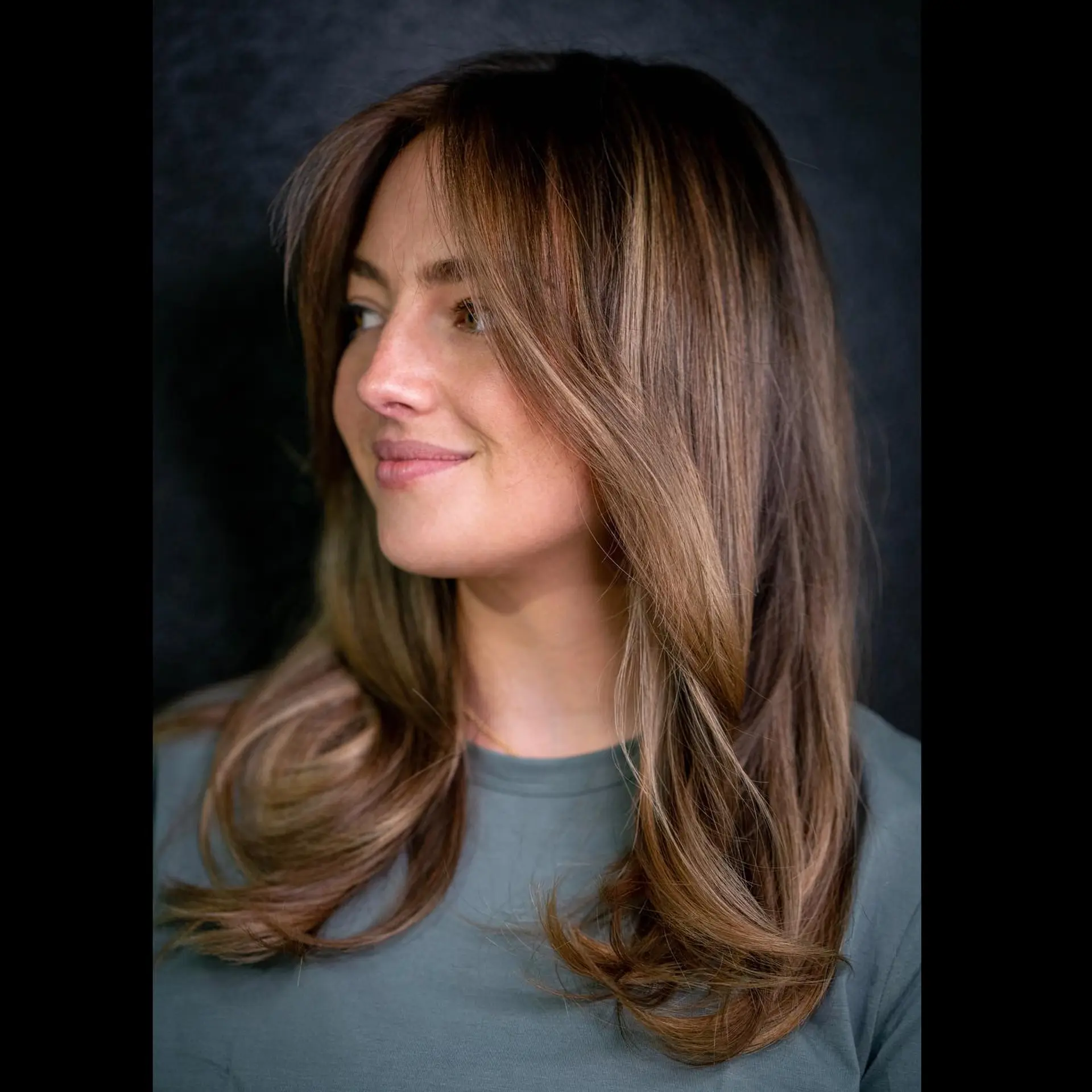 A medium-length wavy hairstyle featuring a bronde balayage and face-framing layers. 1