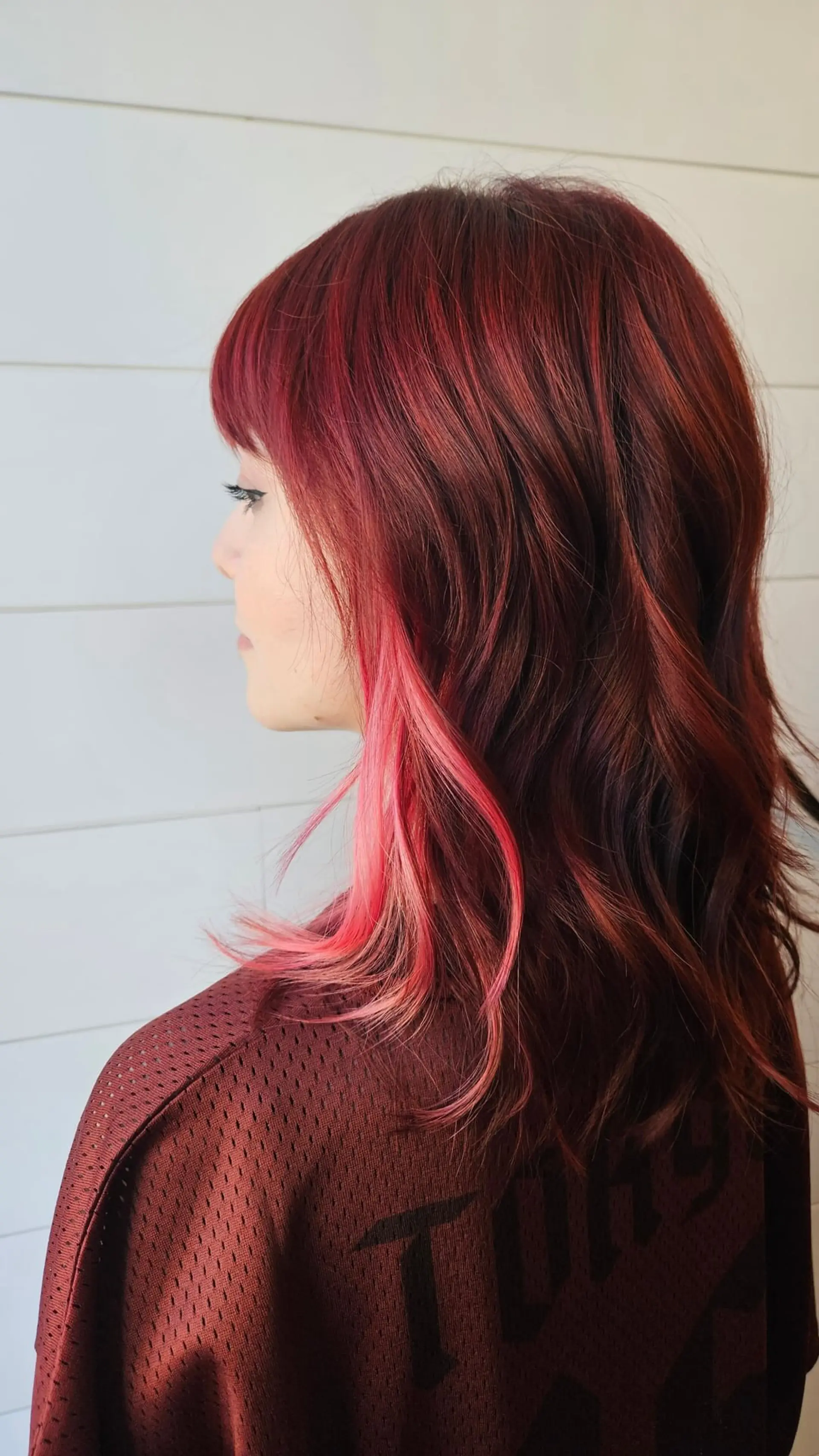Medium-length textured shag with fringe, featuring a rich red base and bright pink peekaboo underlights. 1