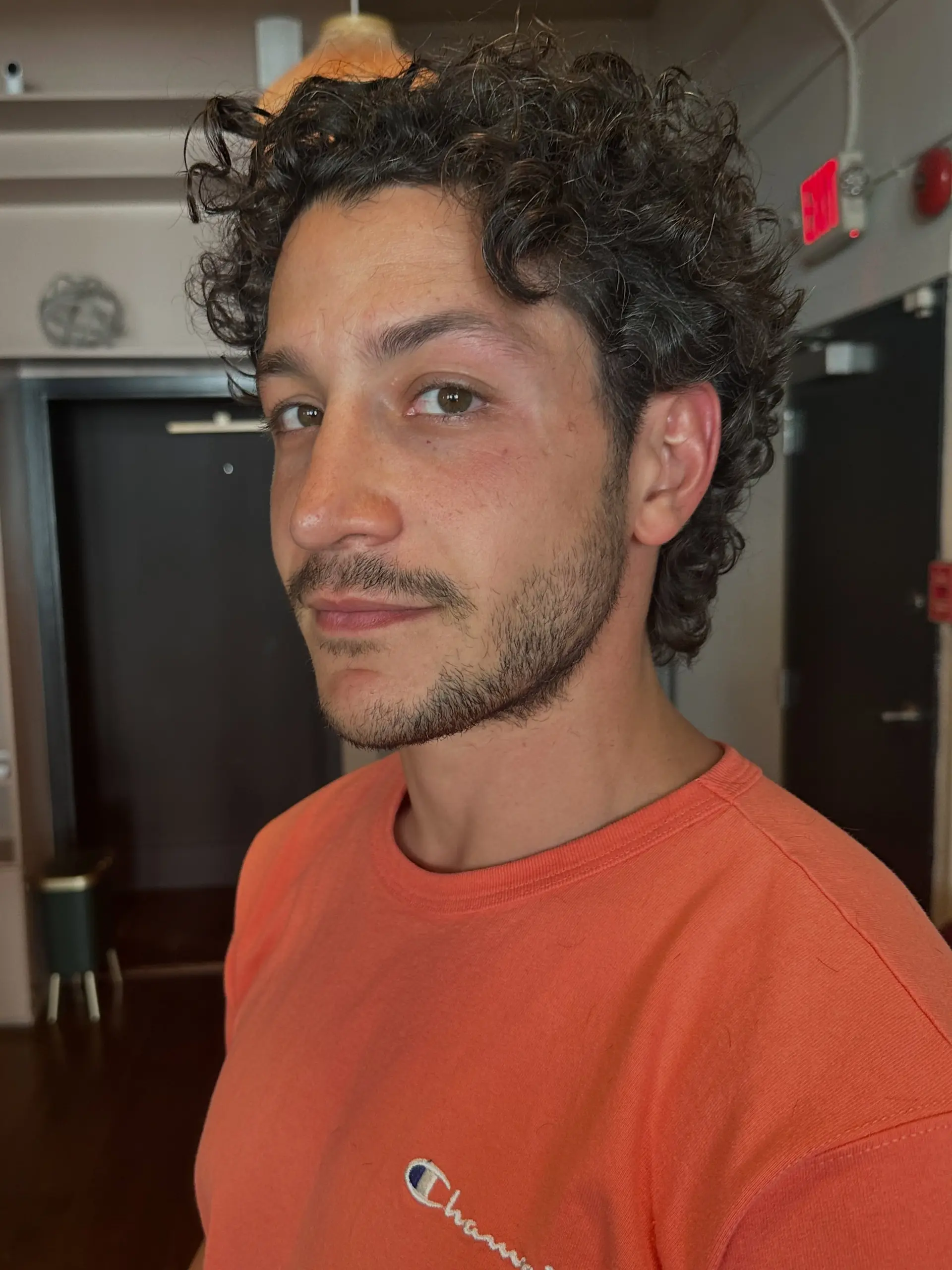 Short naturally curly haircut with defined curls and light volume on top. 1
