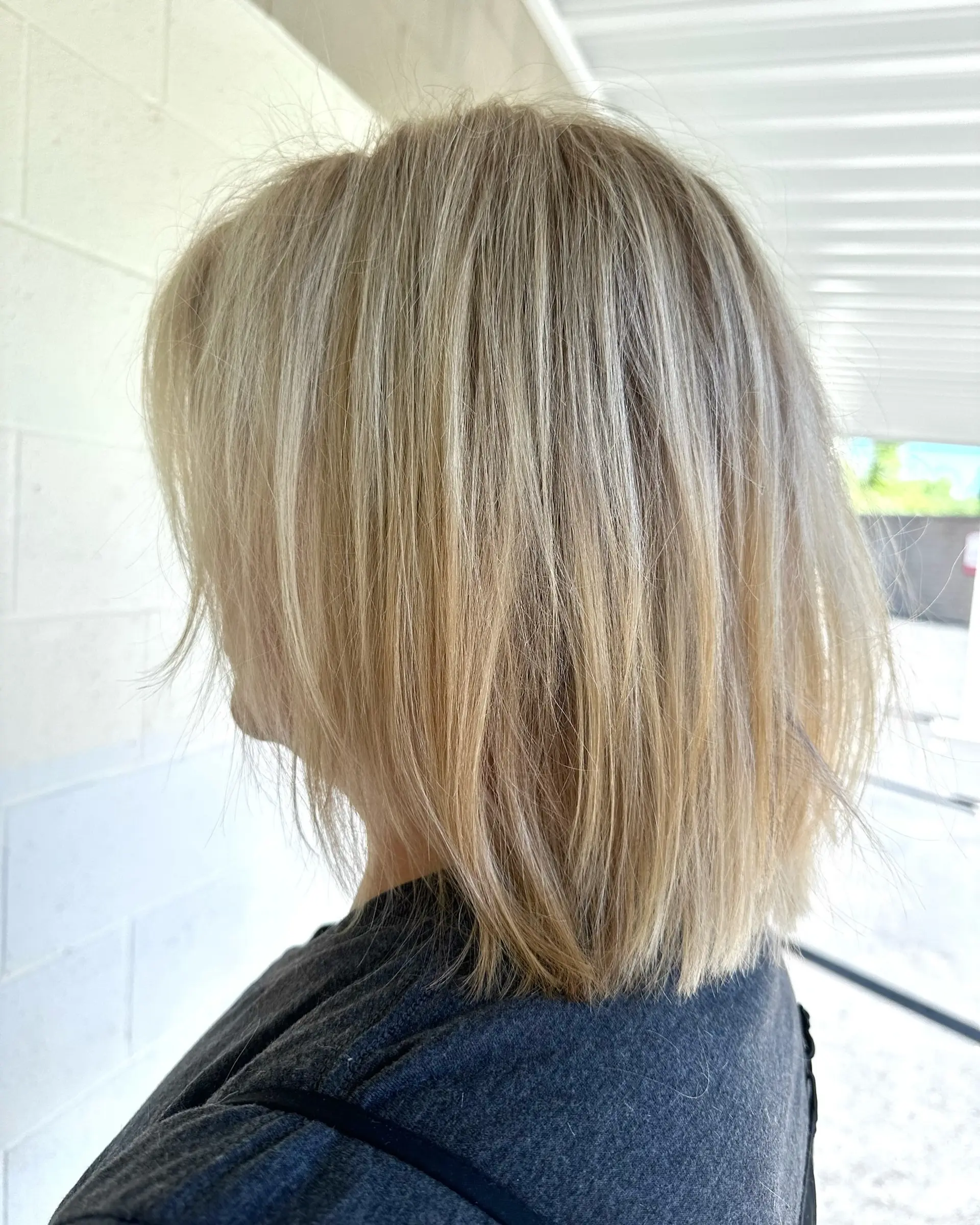 A straight, textured blonde bob haircut falling just above the shoulders. 1