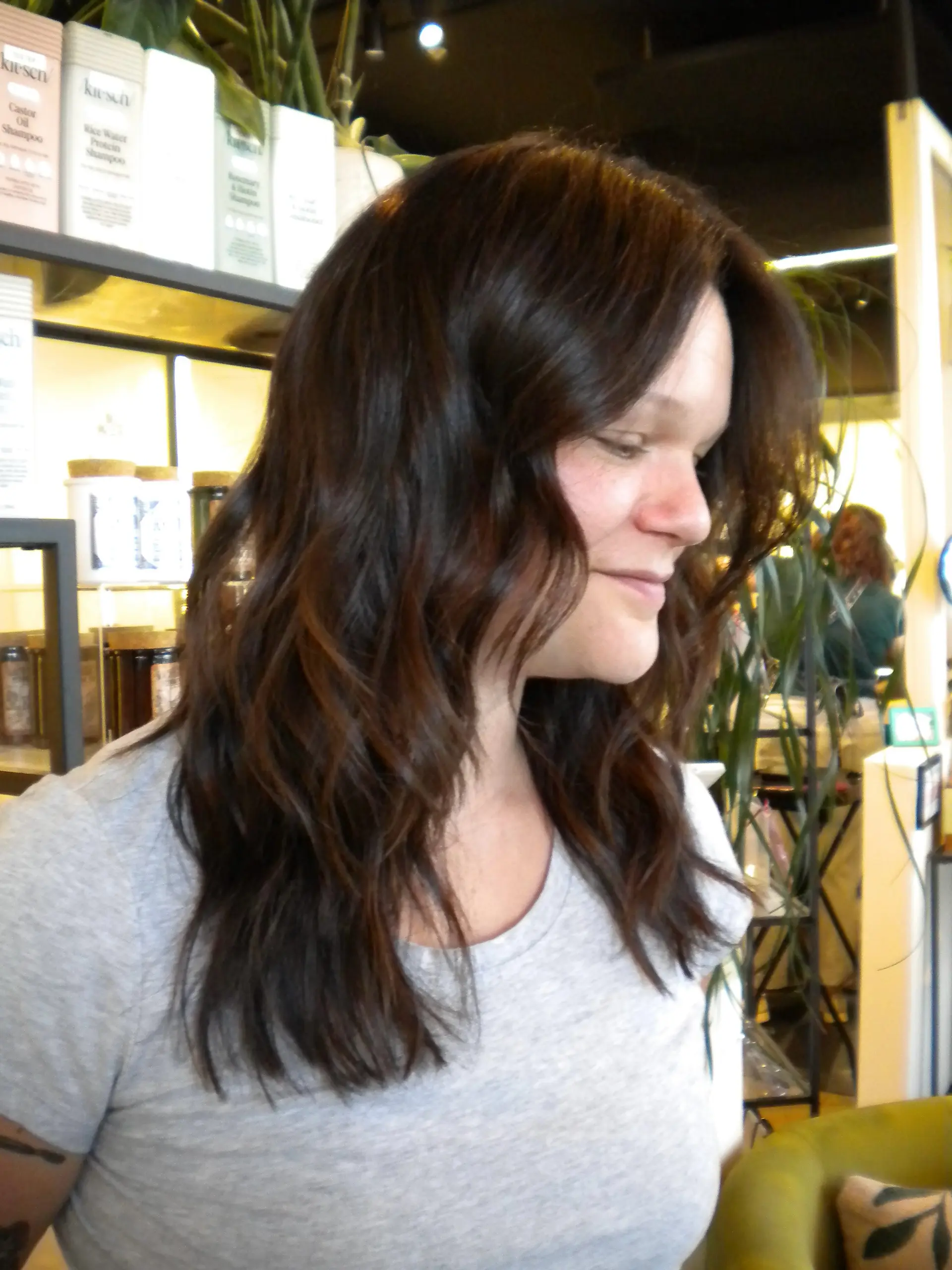 Long dark brown hair cut with subtle layers and styled into soft, flowing waves. 1
