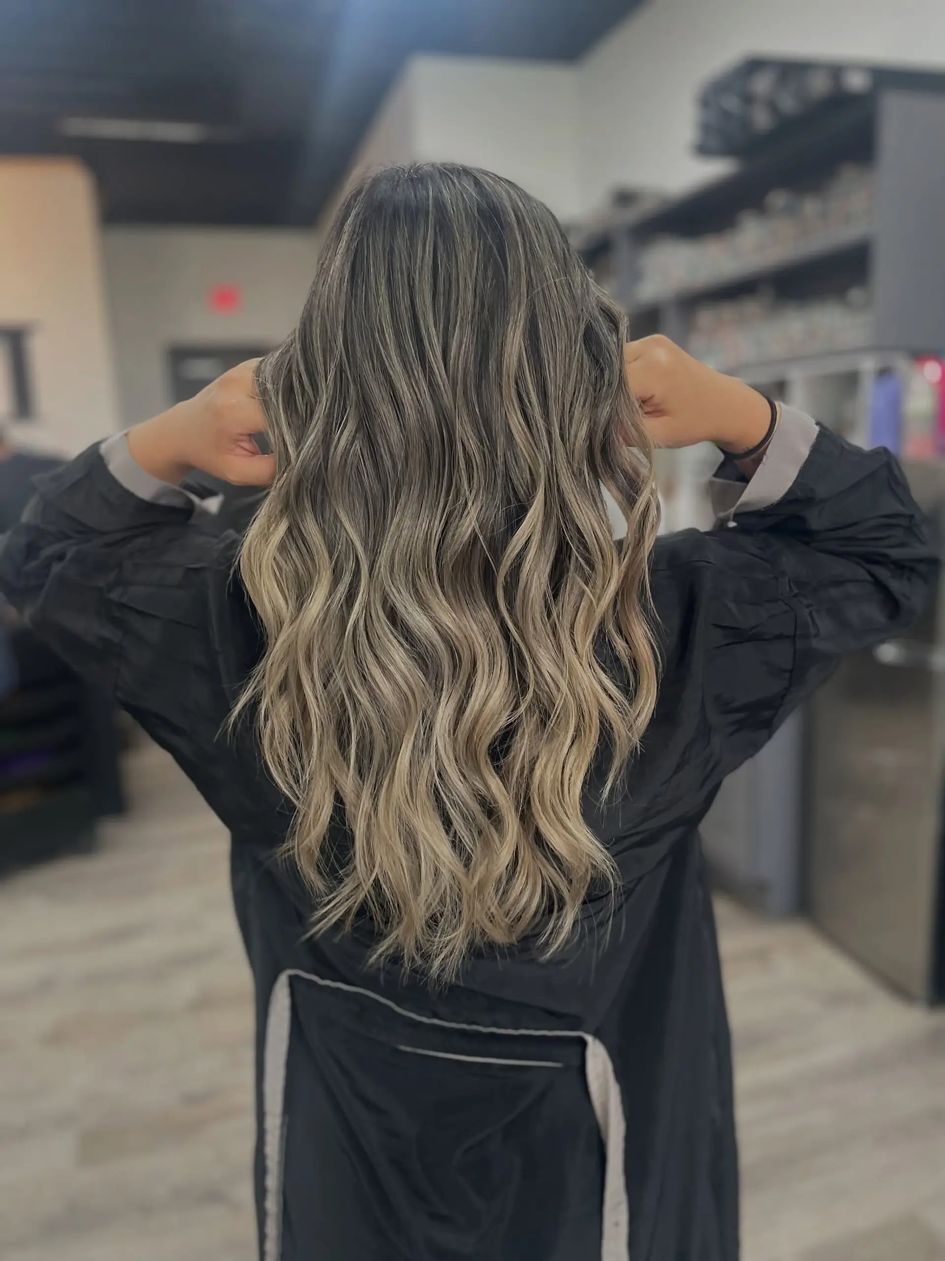 A long, wavy hairstyle with an ash blonde balayage and darker roots. 1
