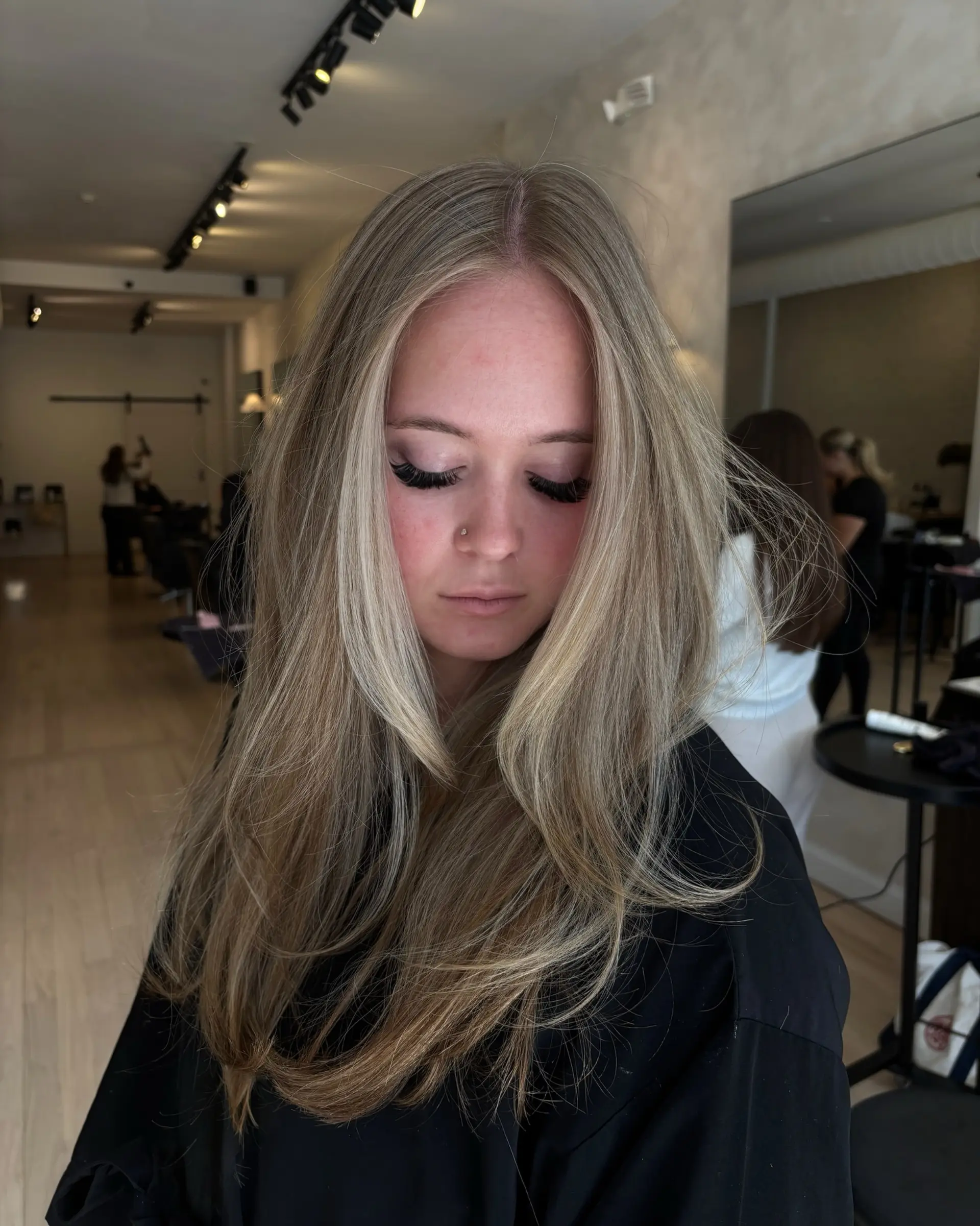 Long dimensional blonde hair styled with a voluminous blowout and soft face-framing layers. 1