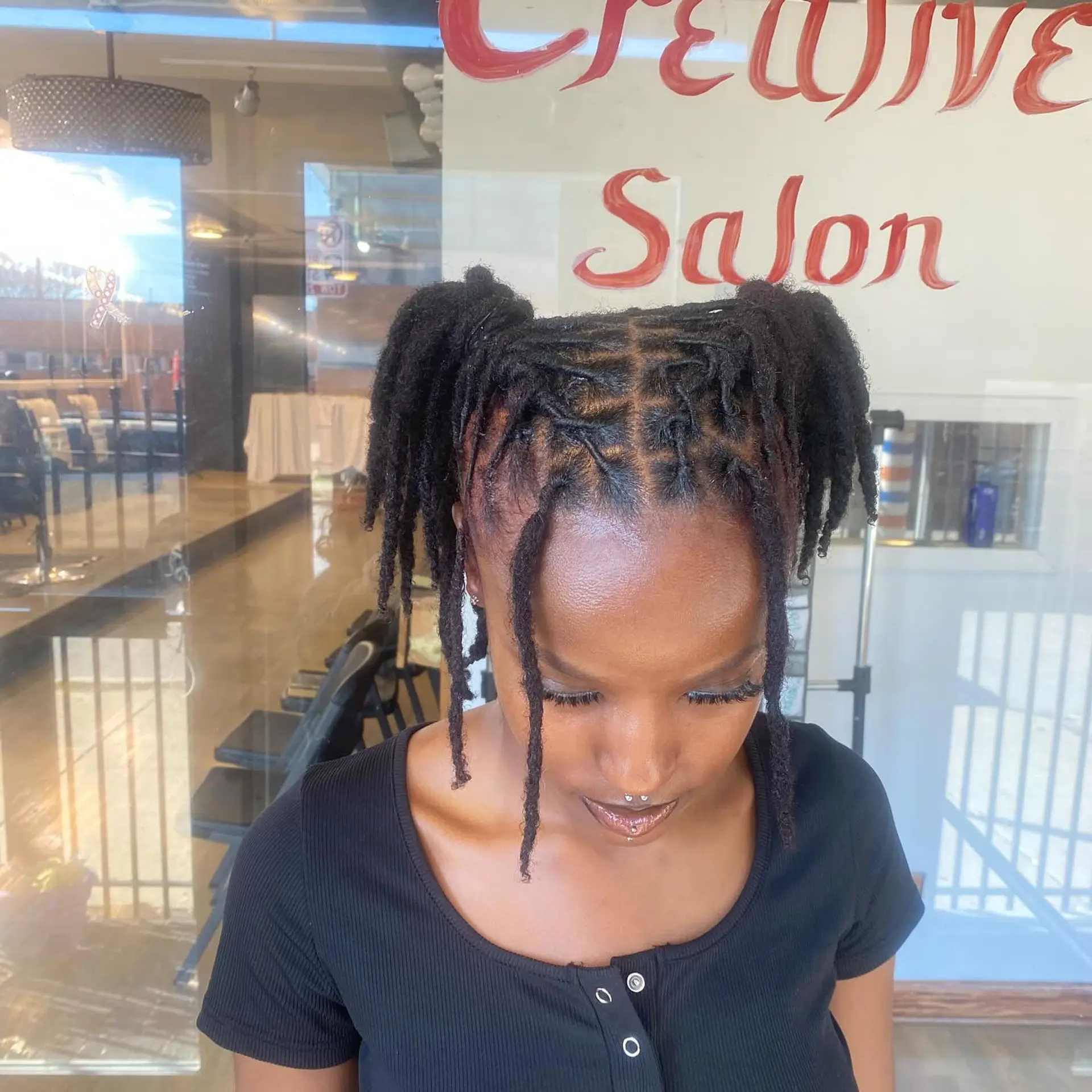 Protective locs styled into a ponytail with a braided base. 2