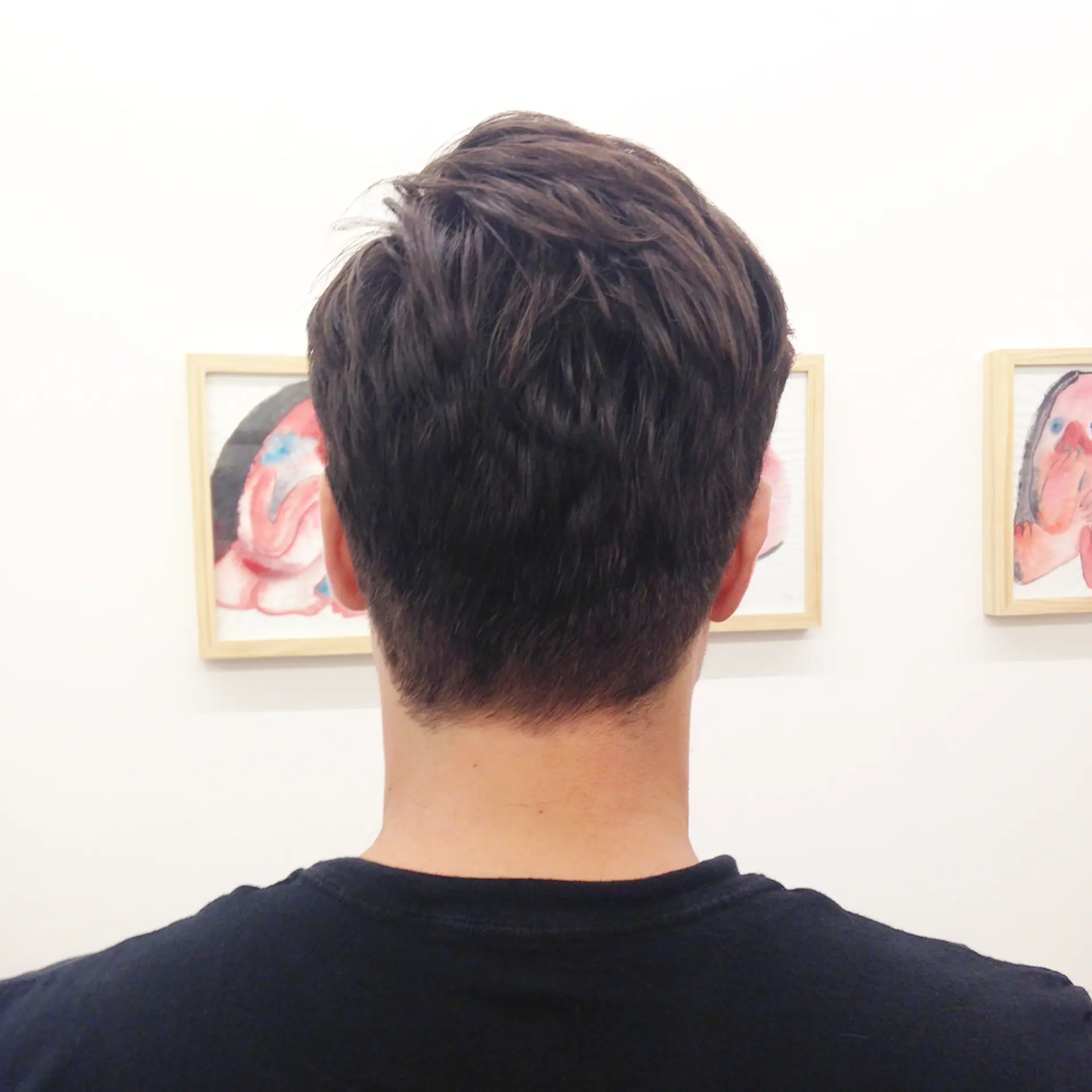 The hair is dark brown, wavy, and short, featuring a distinct side part with natural volume, creating a slightly messy yet controlled look. Clean lines around the edges add sophistication. 3