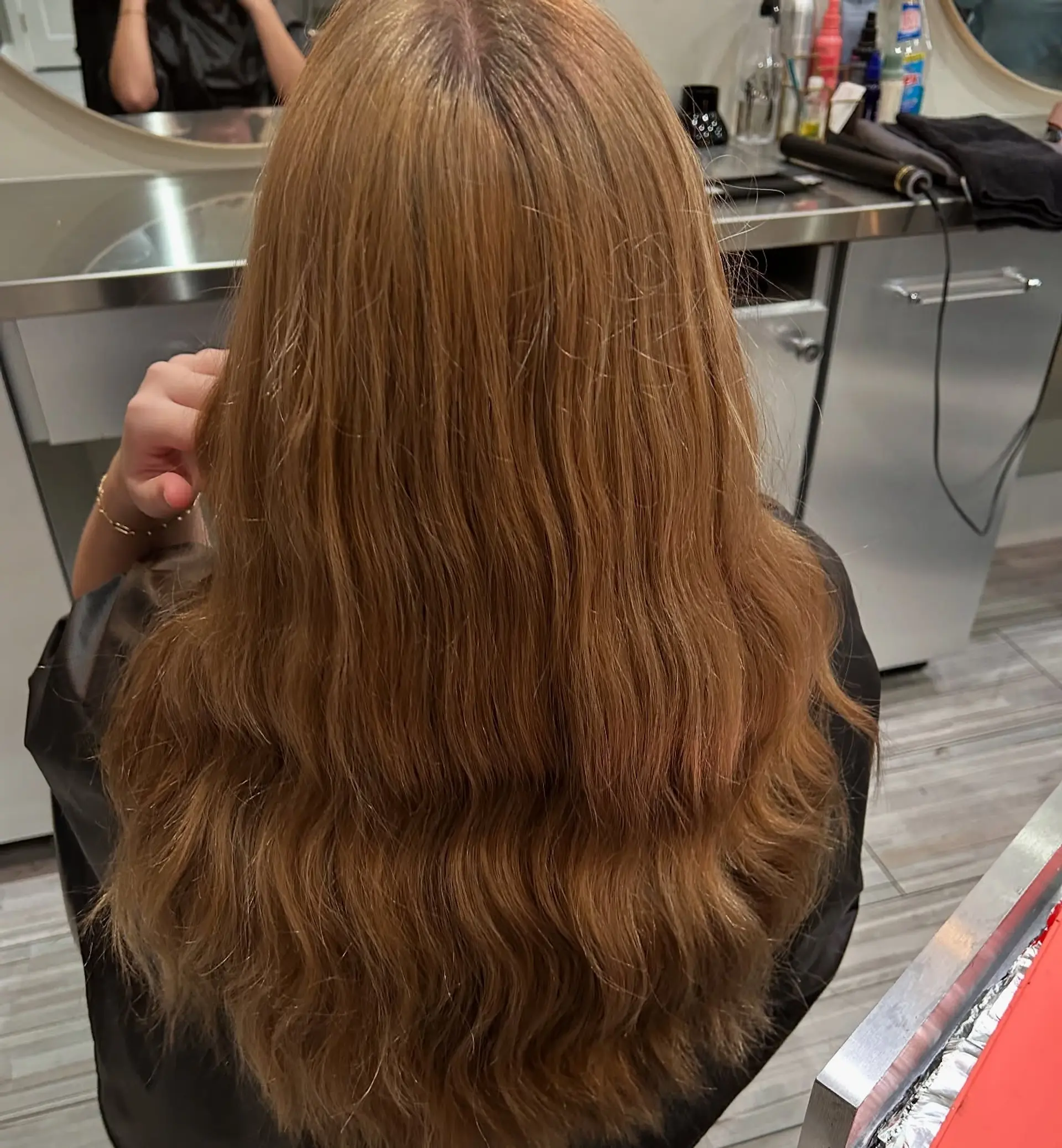 Long warm caramel-brown hair styled with soft, cascading waves and natural texture. 1