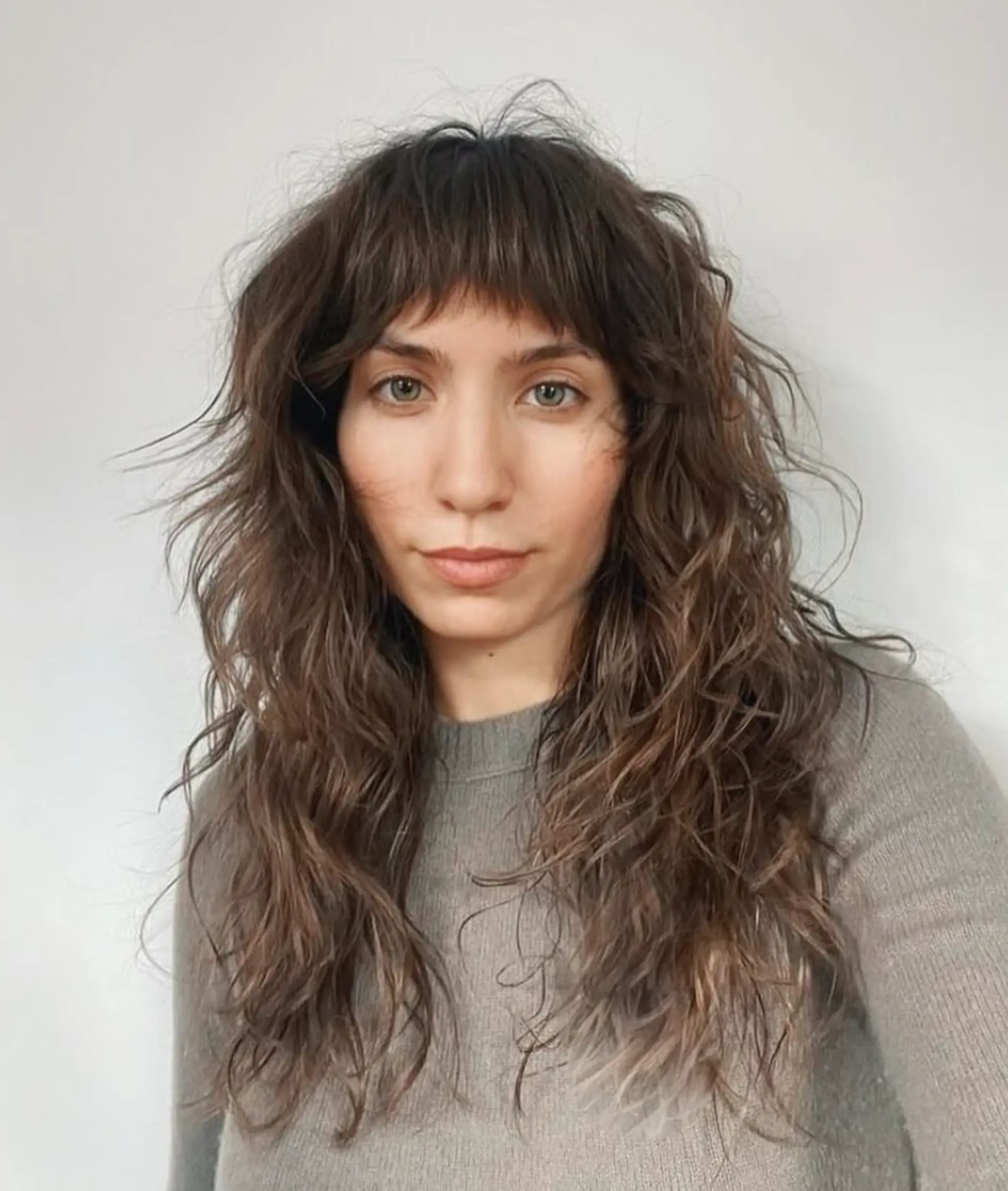 Long, wavy hairstyle with textured waves, wispy layers, and a soft fringe. The rich brown color adds depth to the natural, effortless style.

Cut and style by @juliamannino_hair