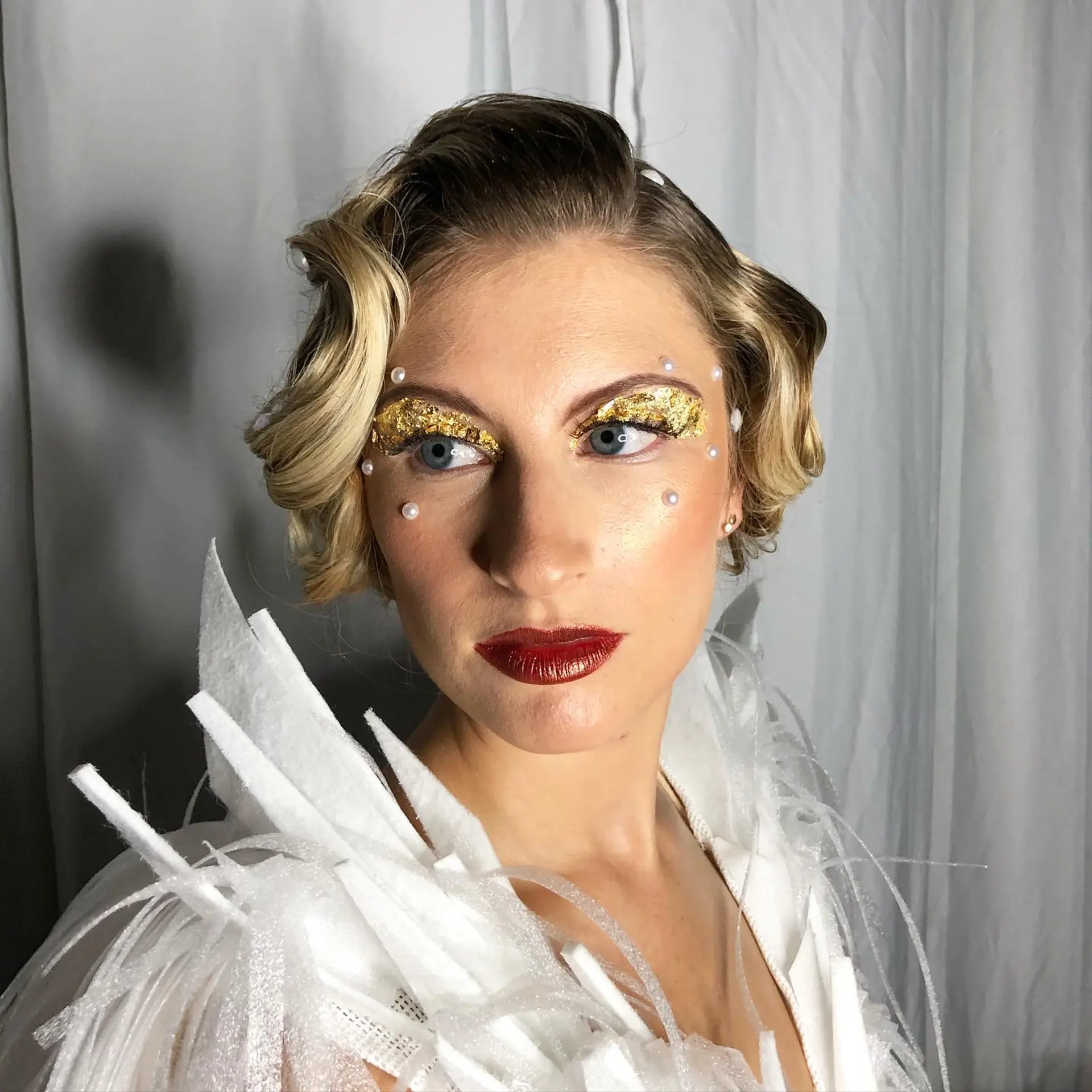A vintage-inspired finger wave style featuring glossy, sculpted S-waves and pearl hair accents. 1
