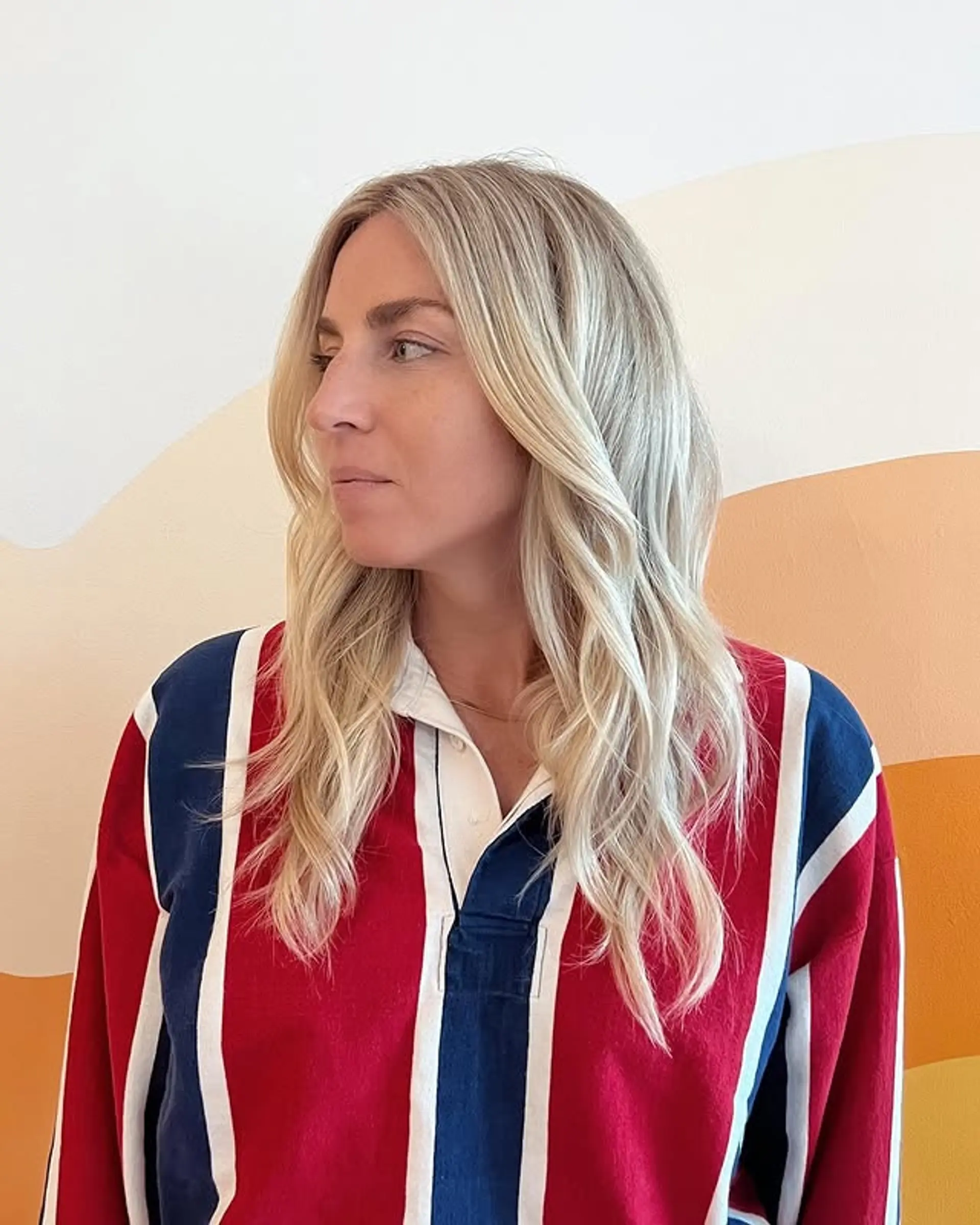 A wavy, medium-length hairstyle with blonde balayage highlights. 1