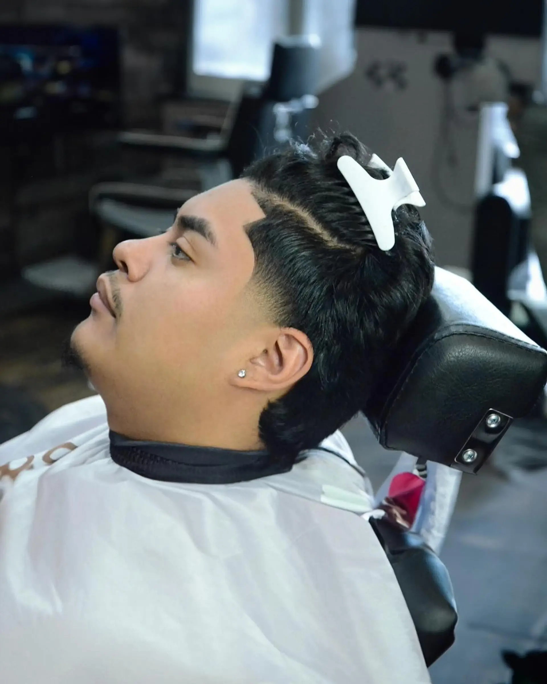 A precise low taper fade paired with a sharp, defined line-up along the temple and forehead. 1