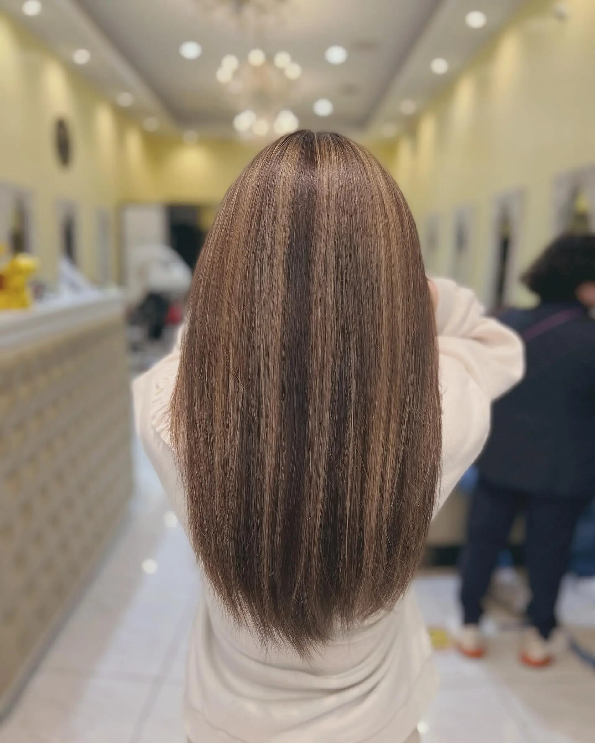 A classic long straight hairstyle with subtle highlights, offering a low-maintenance and natural look. 1