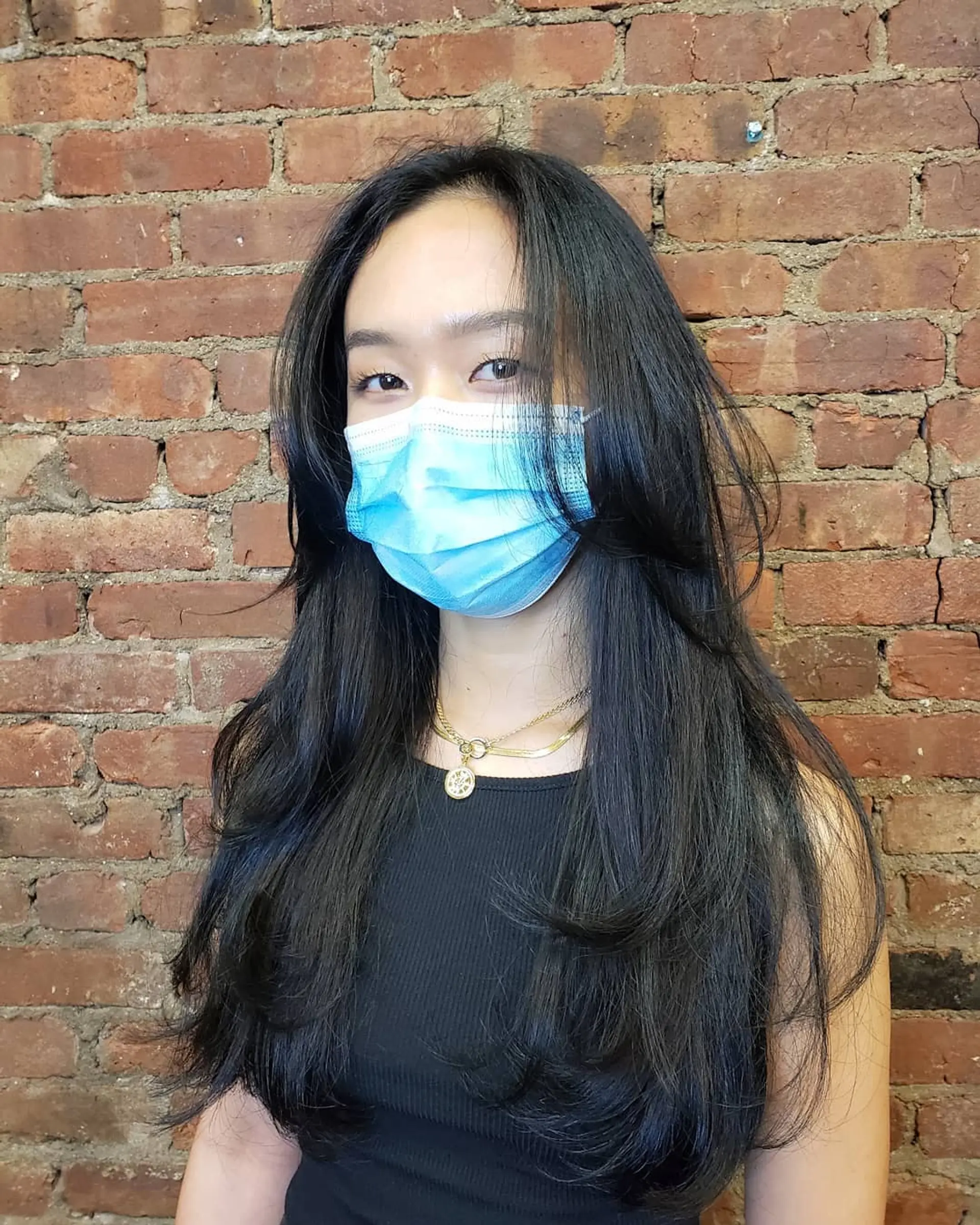 Long black hair styled with soft, textured face-framing layers and inward-curved ends. 1