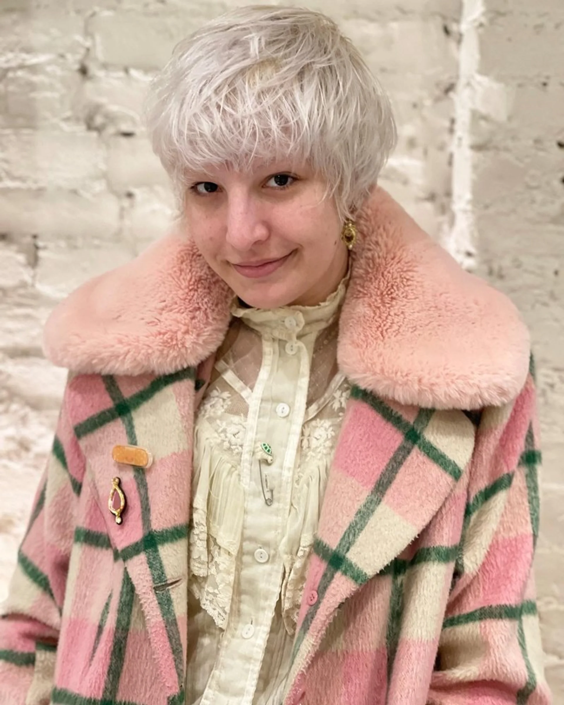 Woman with a platinum blonde pixie buzz cut making a daring statement - Preview 2