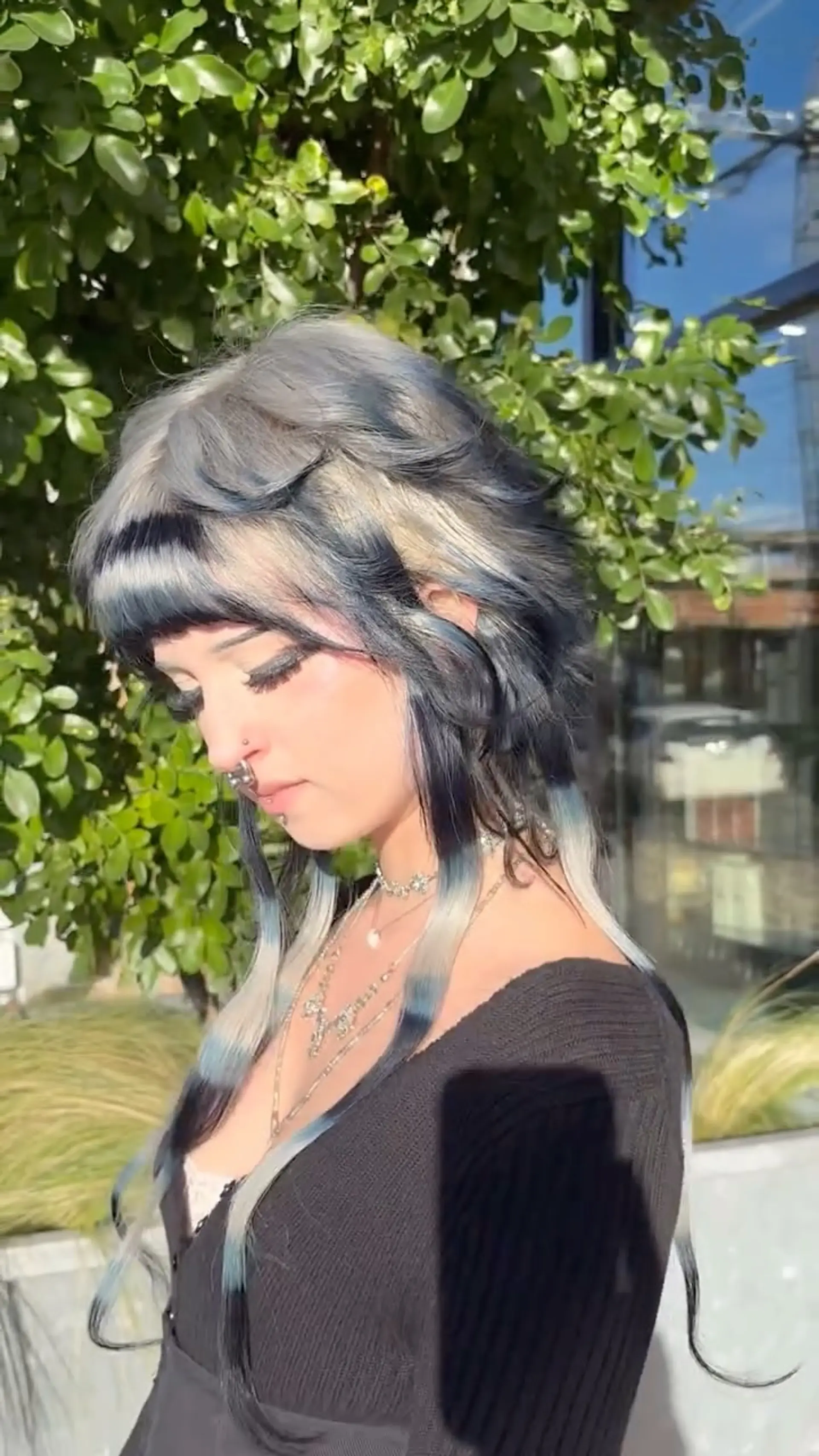 A layered, textured shag mullet with blunt straight bangs and long face-framing tendrils colored in bands of denim blue and platinum blonde. 1