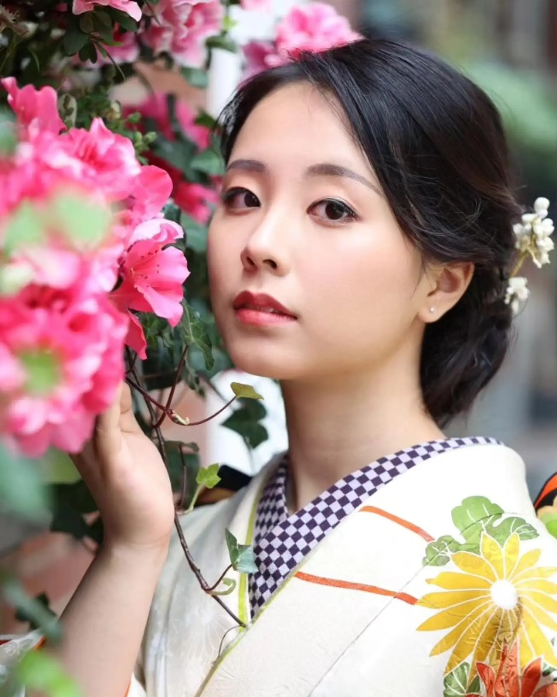 An elegant low updo swept back smoothly and accented with delicate floral hair accessories for traditional attire. 1