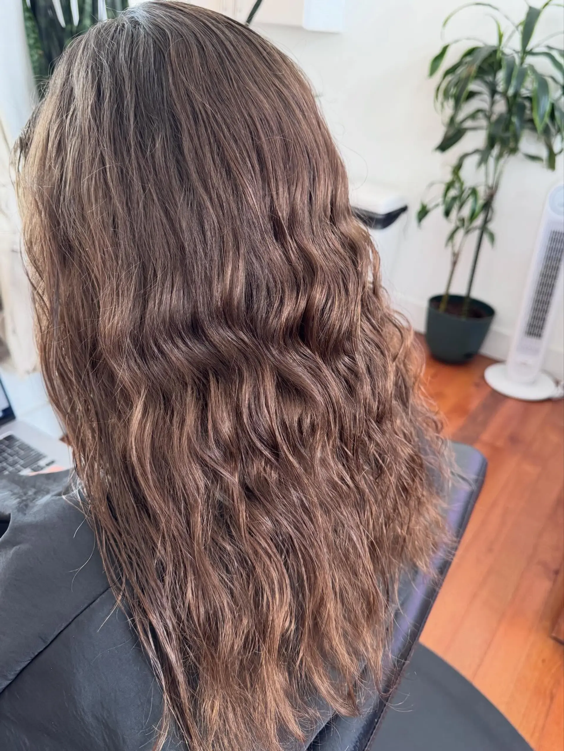 Long dimensional brunette hair styled into loose, textured beach waves. 1
