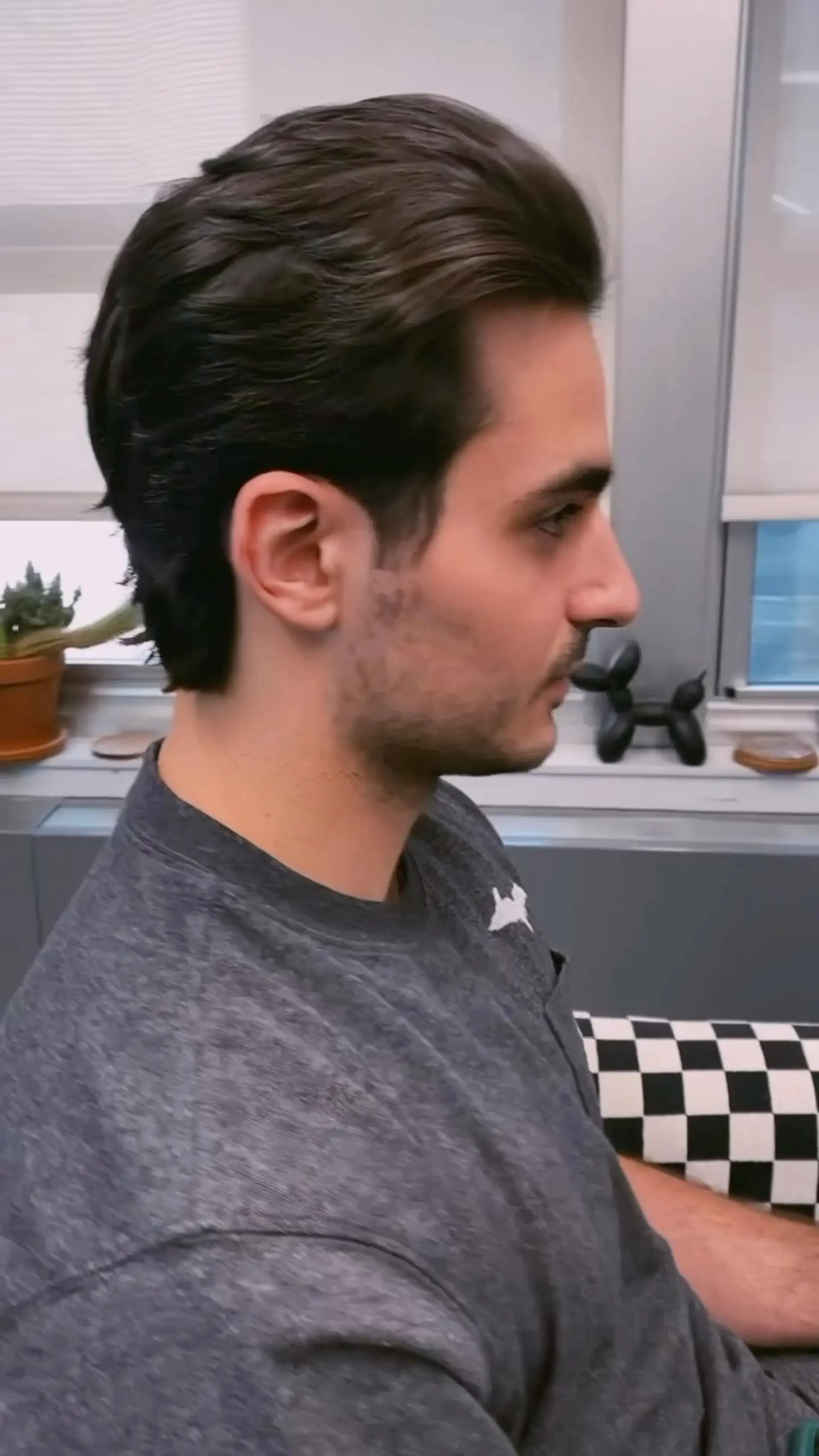 A medium-length men's haircut styled brushed back with natural texture and soft layering. 1