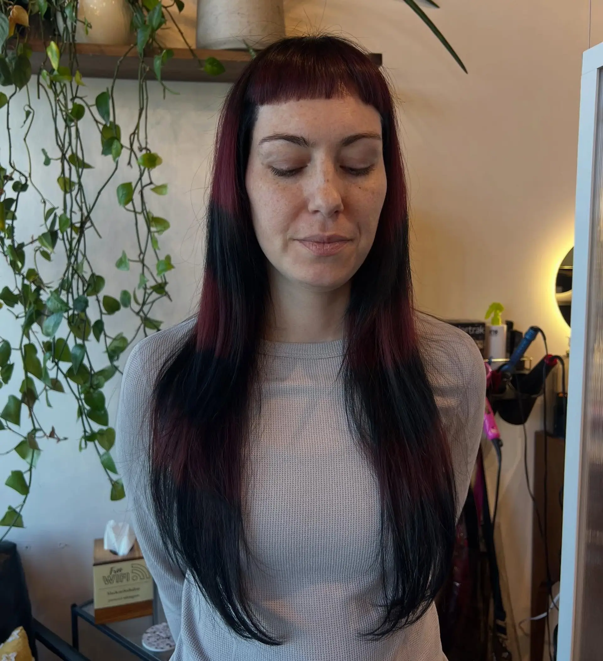 Long straight hair featuring blunt micro bangs and graphic horizontal bands of deep burgundy and black. 1
