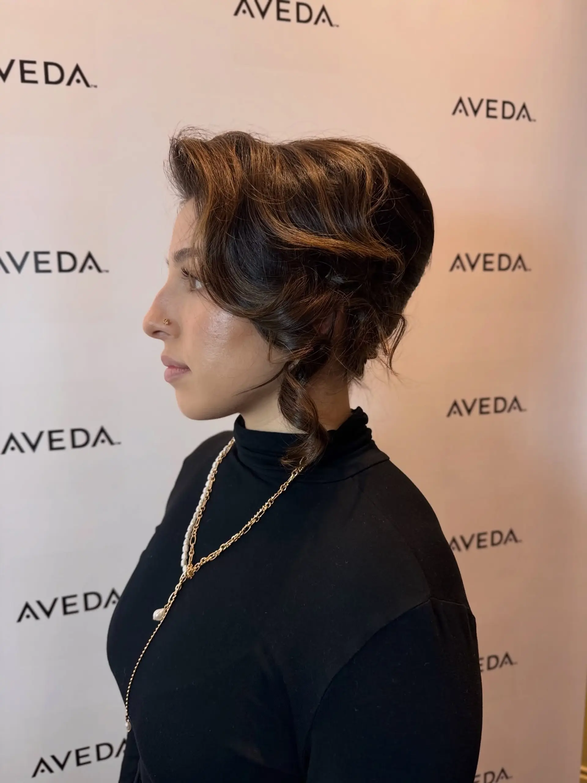 A retro-inspired structured updo with volume at the crown and sculpted wave tendrils framing the face. 1