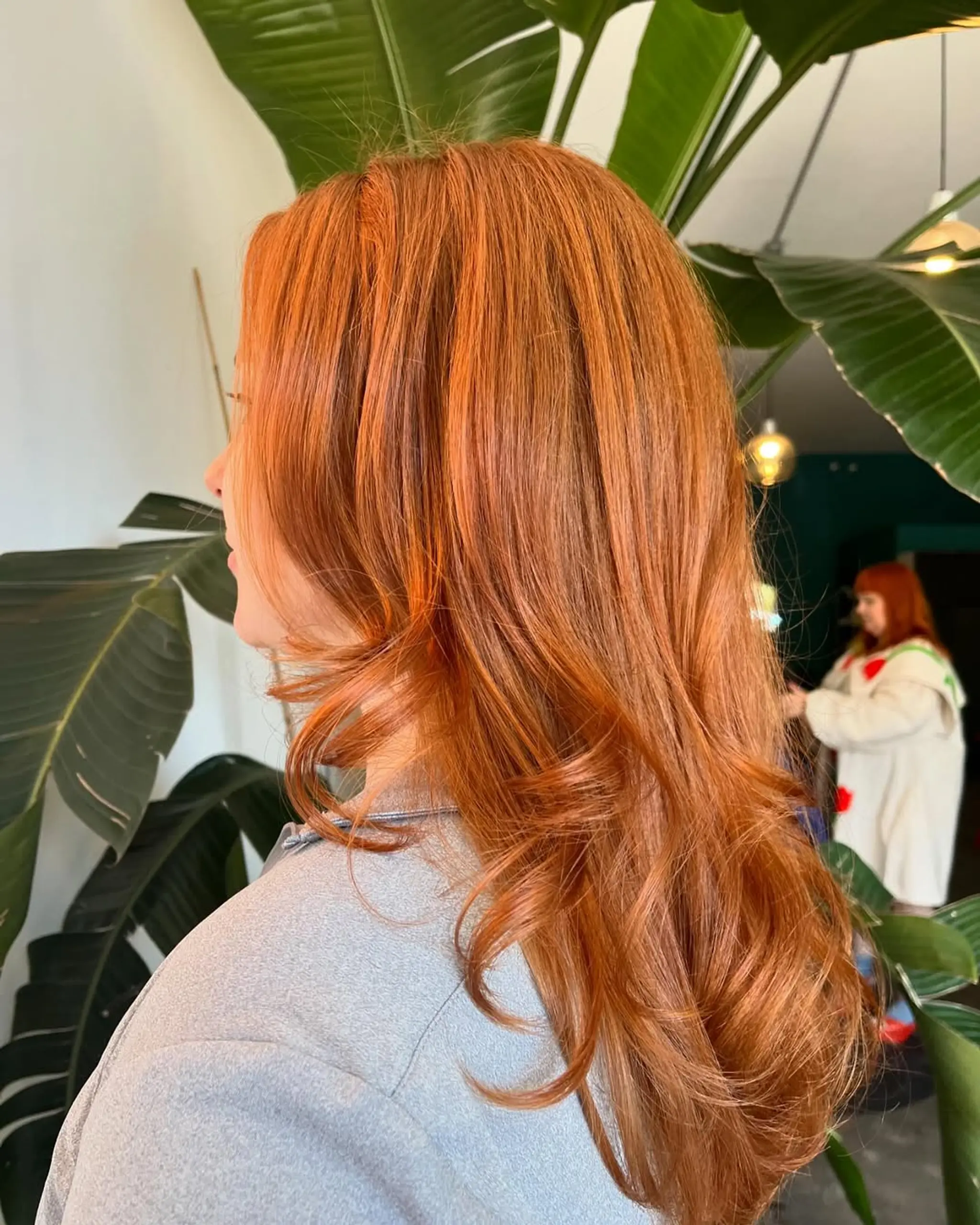Long, wavy copper hair with soft waves and subtle layering for volume and movement.