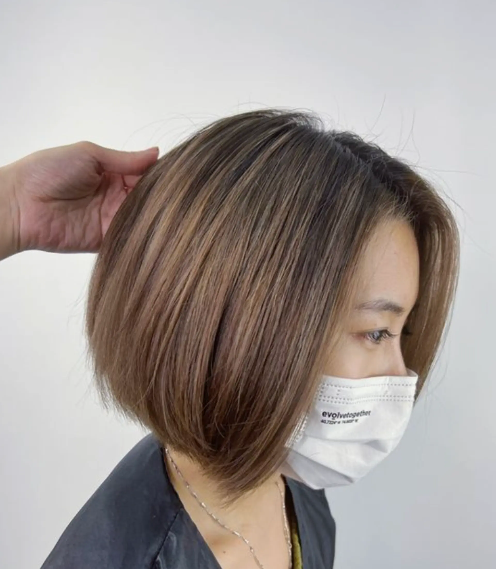 A smooth, straight bob with graduated layers, ending just above the shoulders creating a soft, voluminous look with a subtle side part. 1