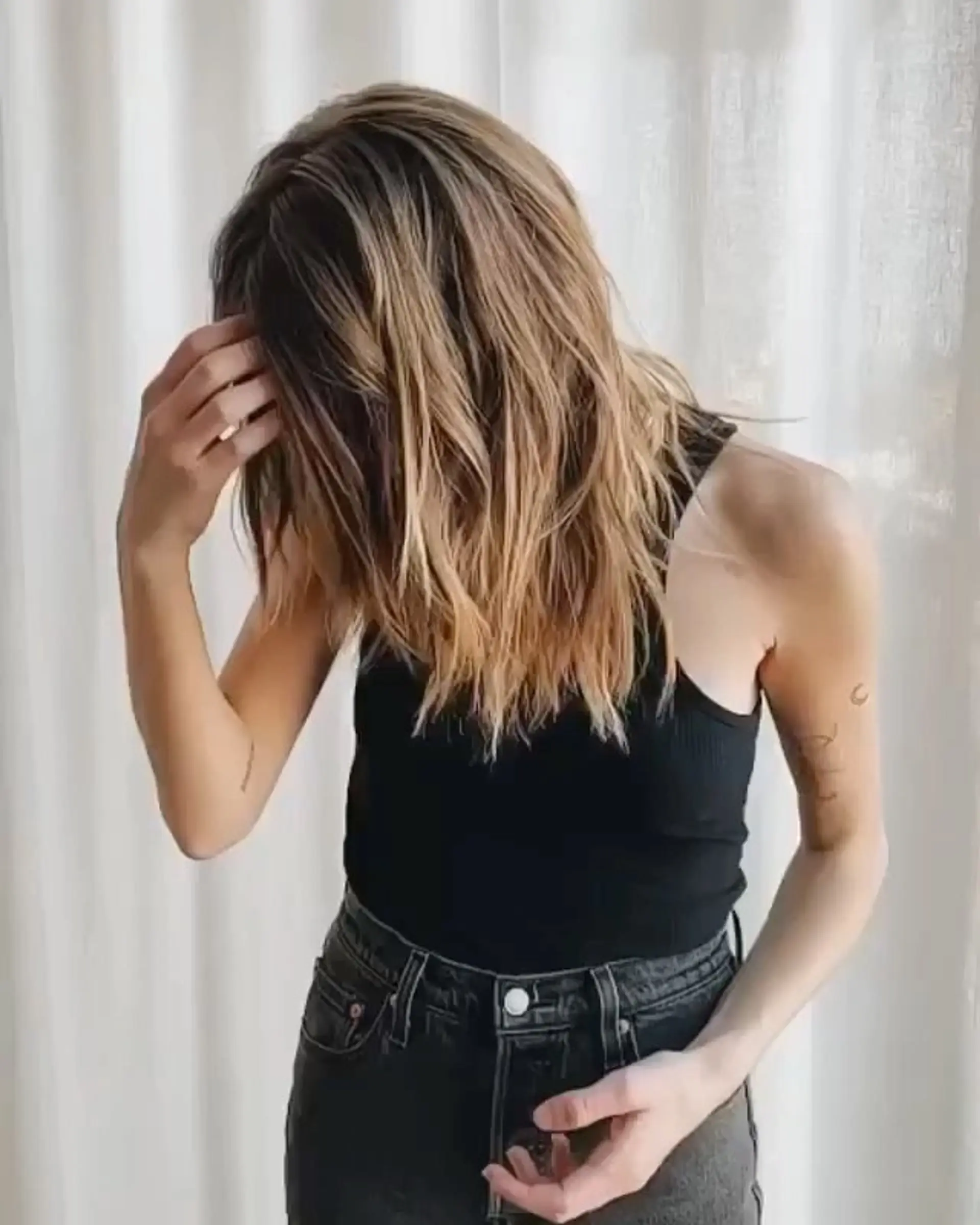 Long, wavy hair with layered cuts and sun-kissed honey blonde highlights, creating natural movement and dimension. 3