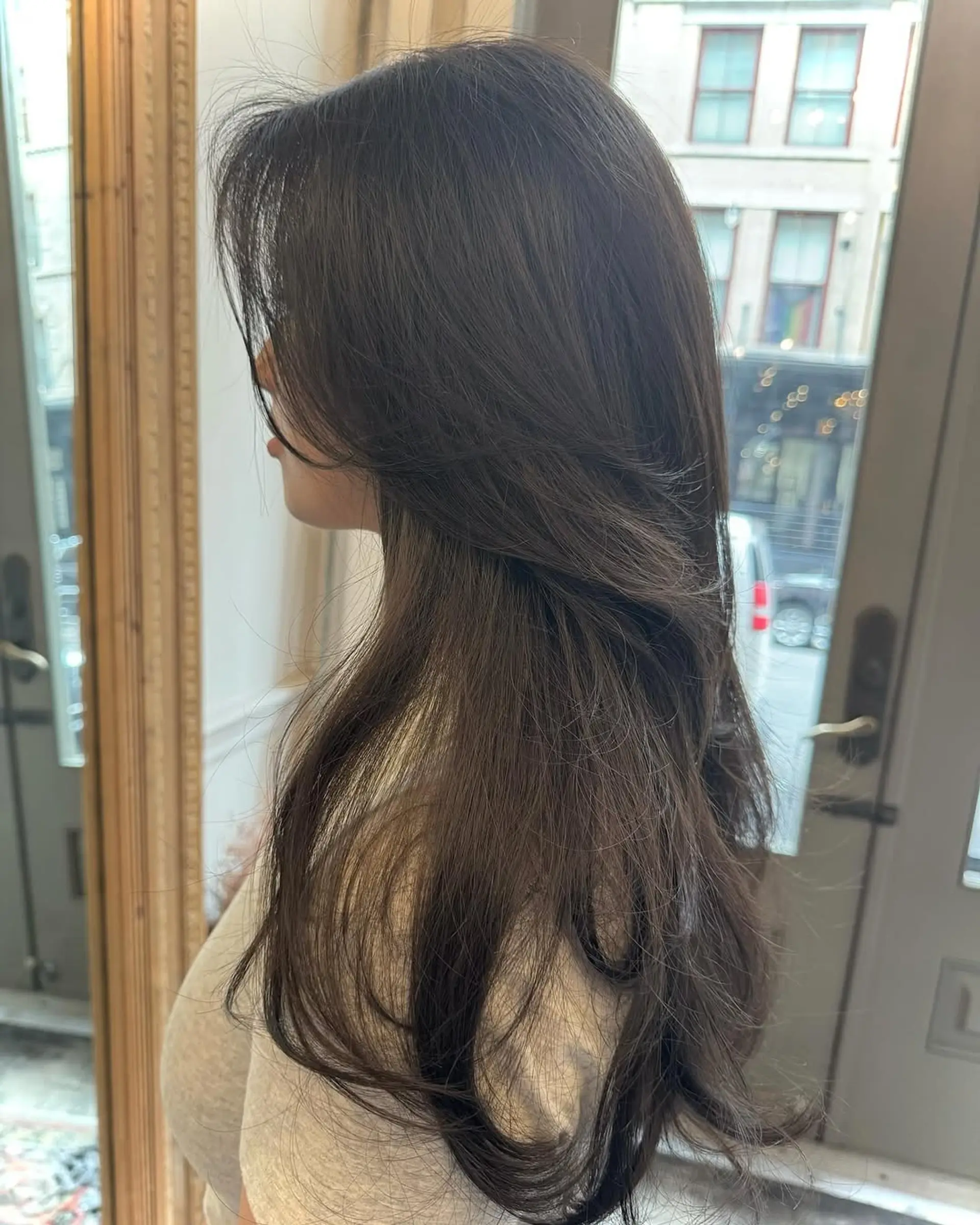 Long, layered, dark brown wavy hair with voluminous face-framing strands. 2