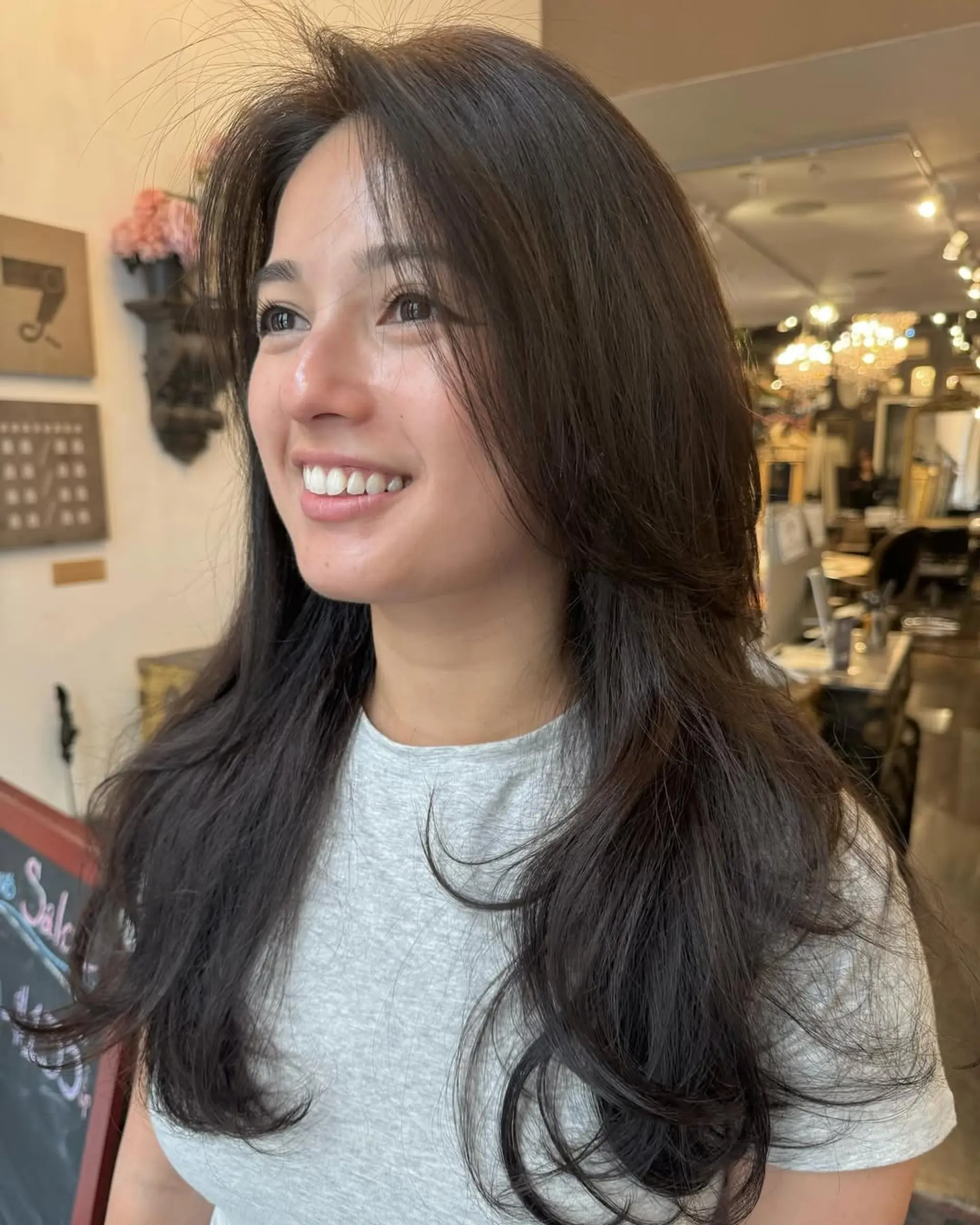 Long, layered, dark brown wavy hair with voluminous face-framing strands. 1